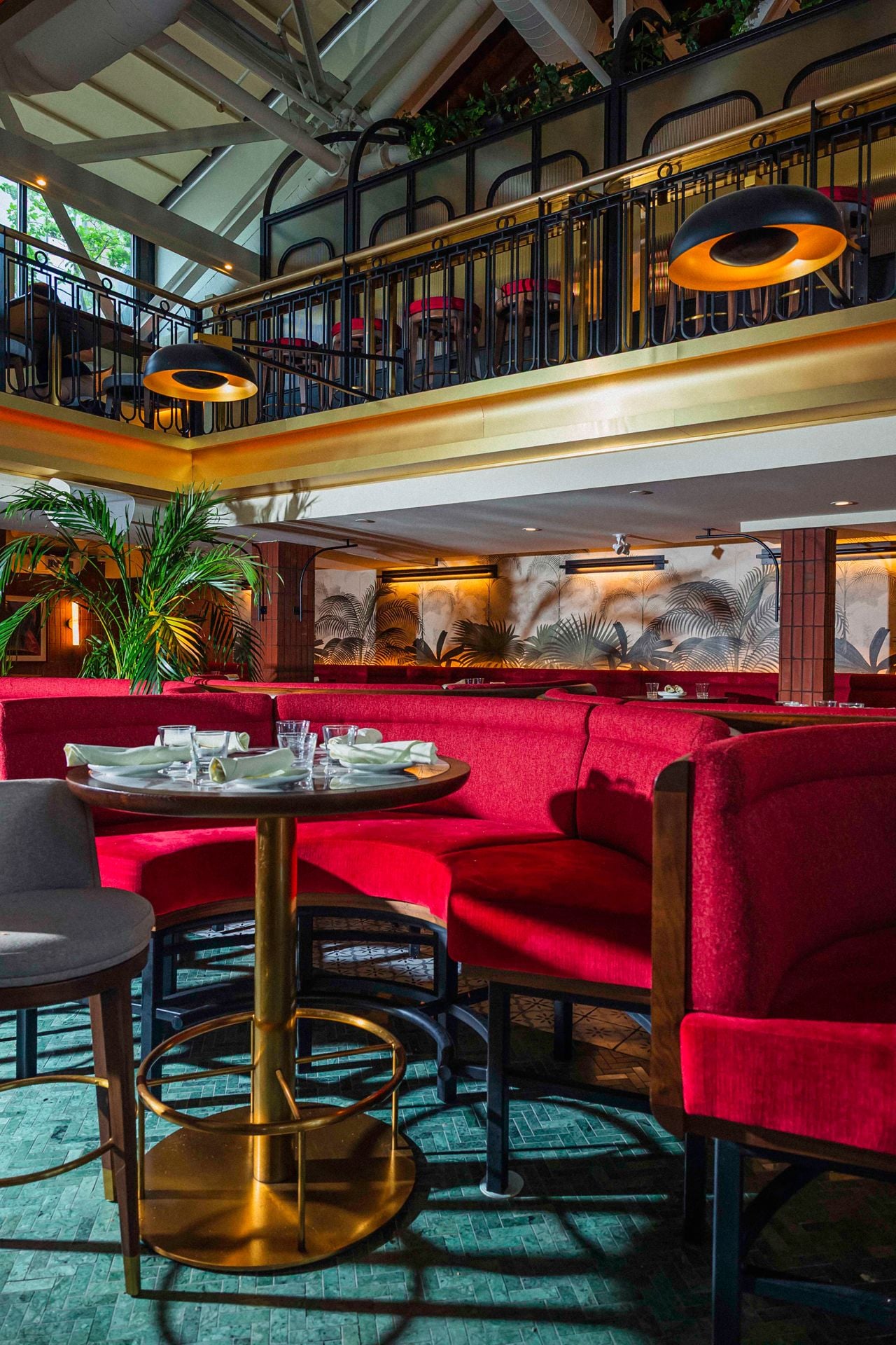 A closeup of the horseshoe-shaped, red velvet booths in the main dining room of Queens Harbour