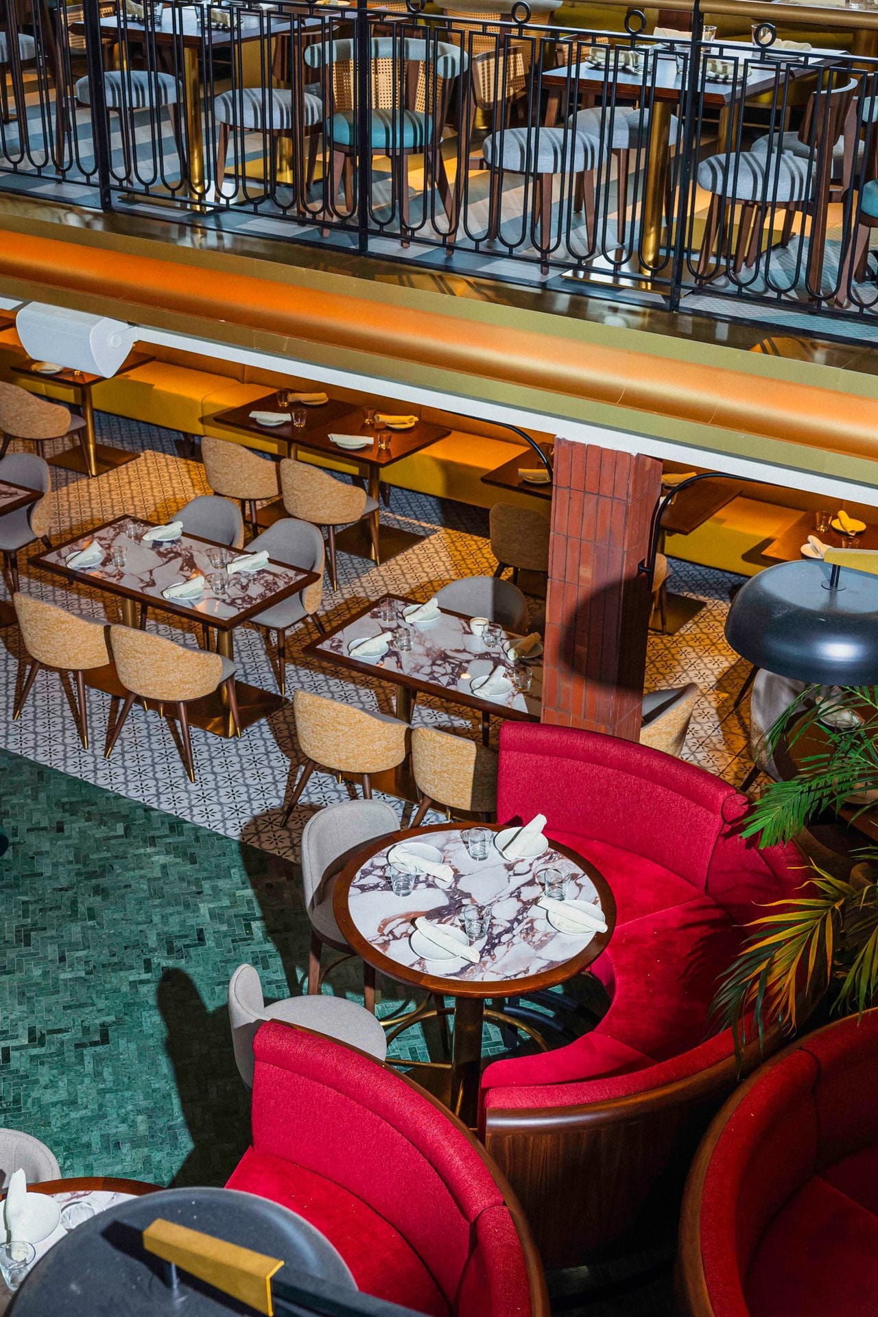 Looking from the second level of Queens Harbour down to red velvet booths below