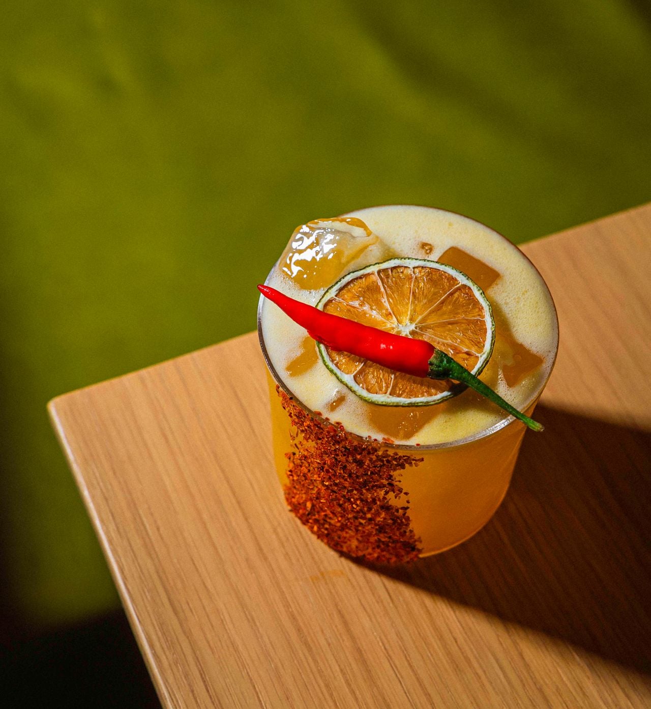 The Spicy and Passion is a blend of Vodka, Triple Sec, lemon, passion fruit, Demerara syrup and spicy bitters, rimmed with Tajin and garnished with a chili pepper