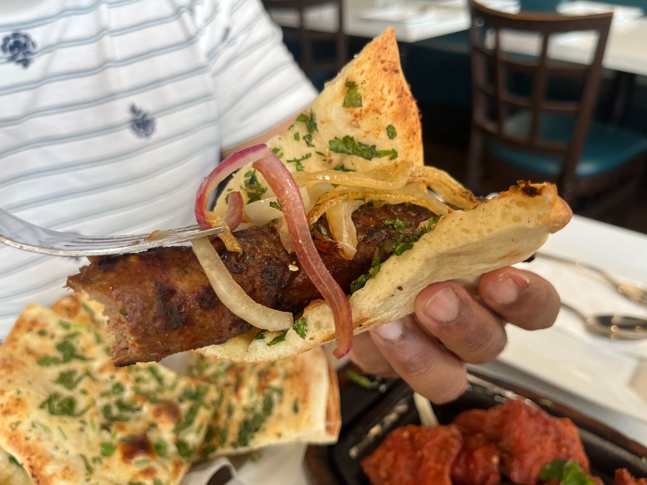 A seekh kebab wrapped up in a piece of naan