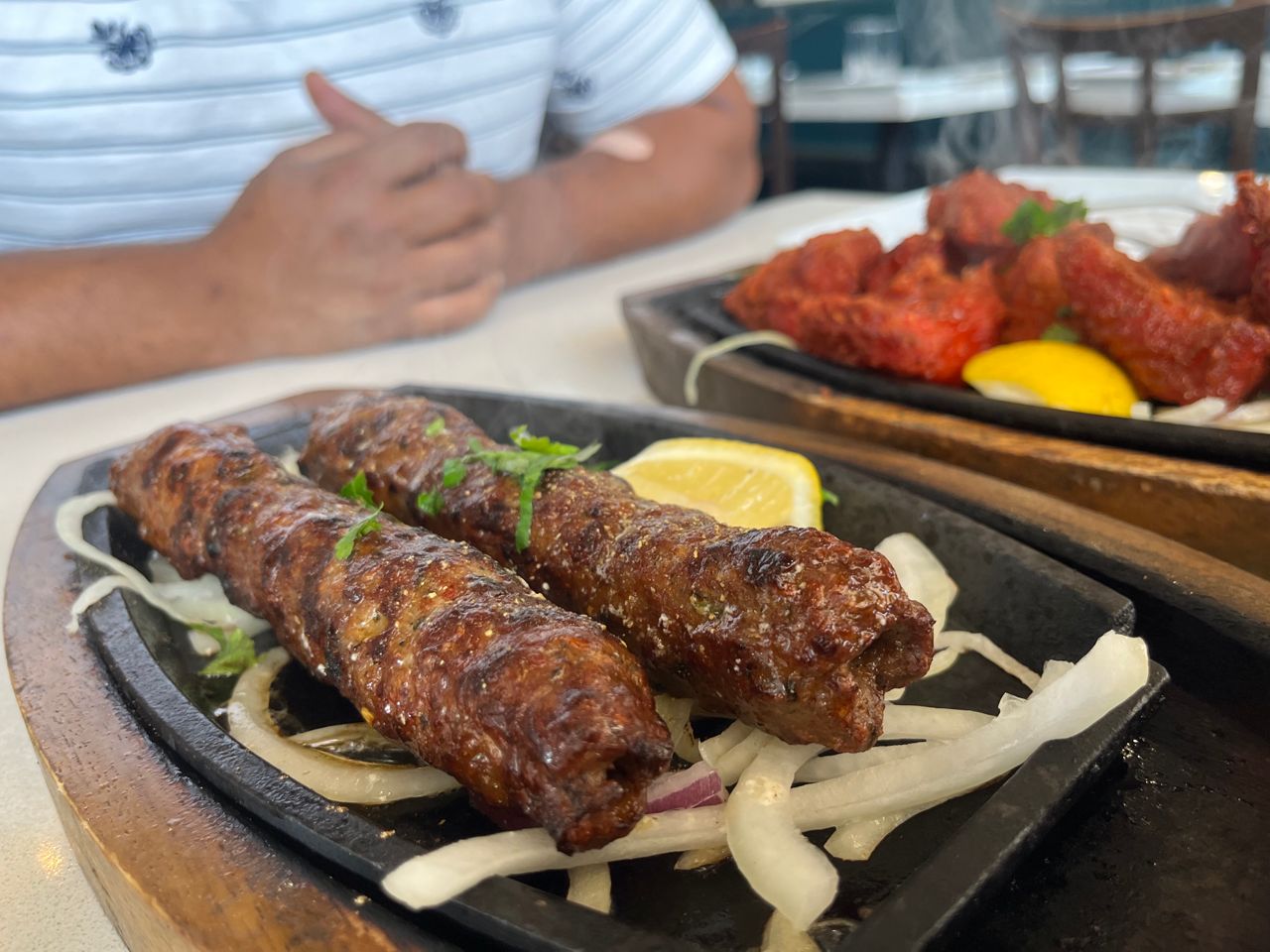 A pair of seekh kebabs on a tray