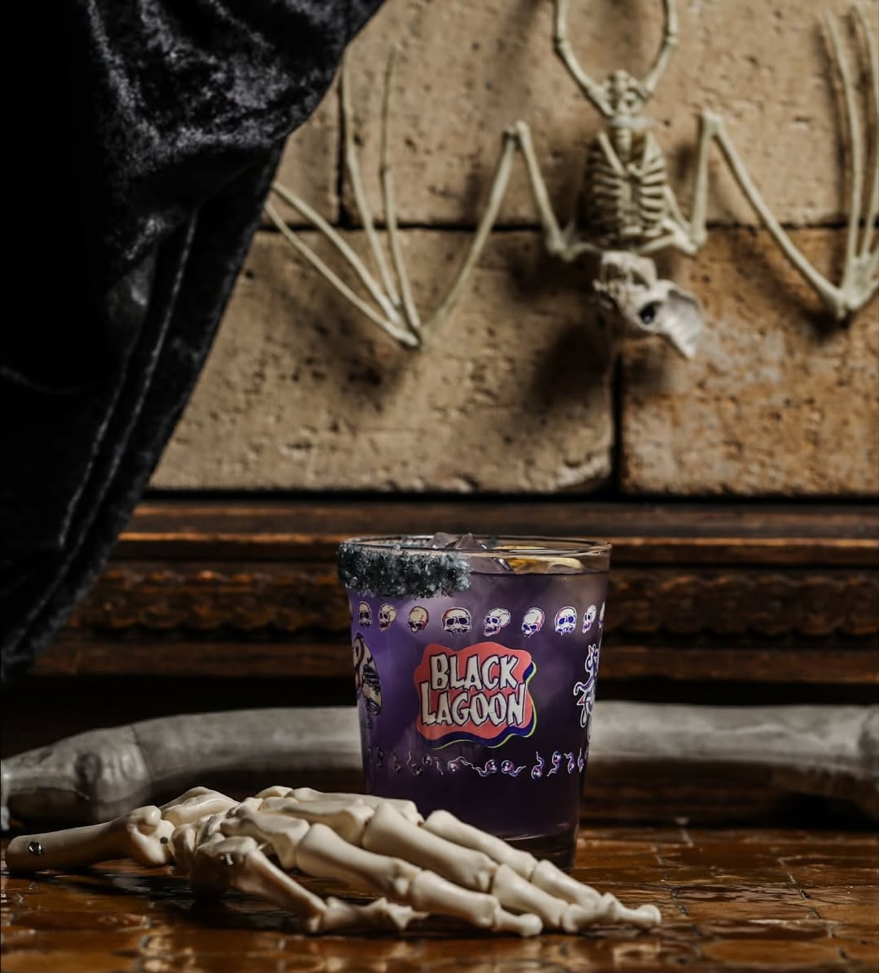 A purple cocktail flanked by fake bones for Halloween