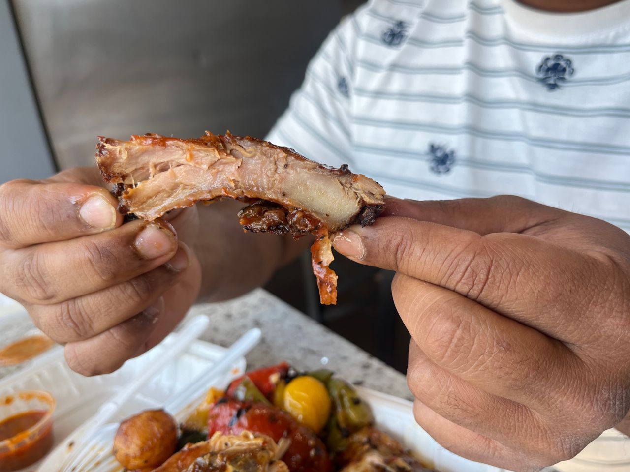 A person holds a rib up to the camera