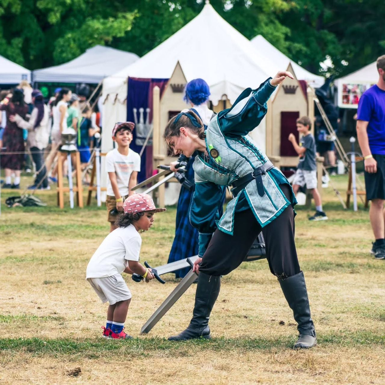 Kid sword fighting with woman in costume