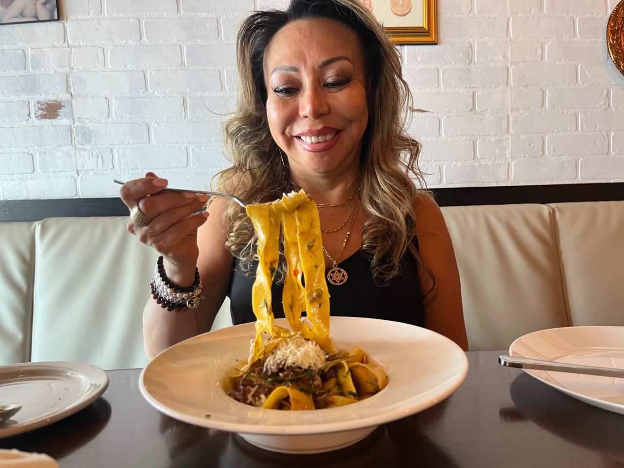 Patricia Toro smiles at a forkful of pasta