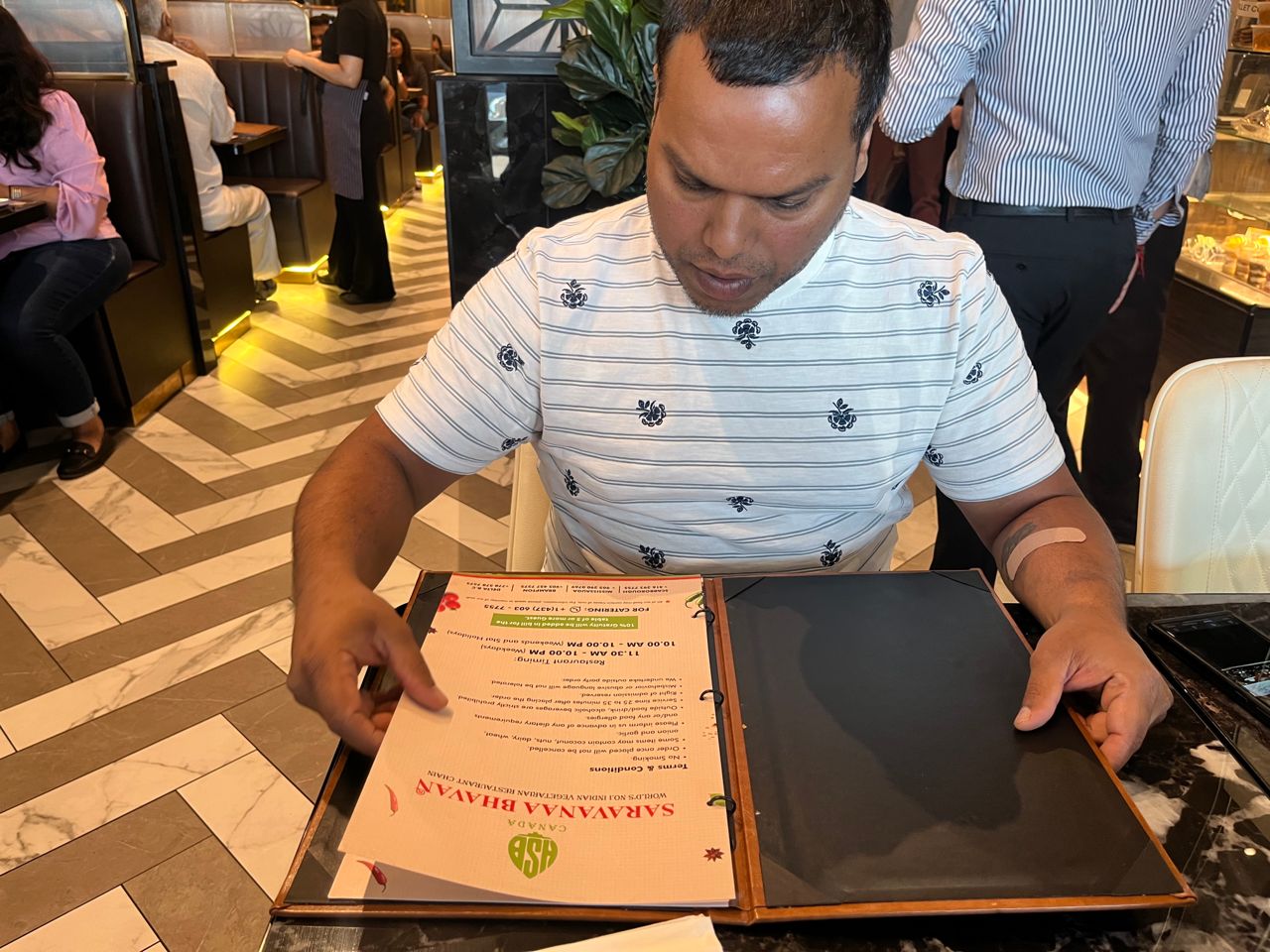 Chef Donnie Gomes reads the menu at Saravanaa Bhavan in Mississauga