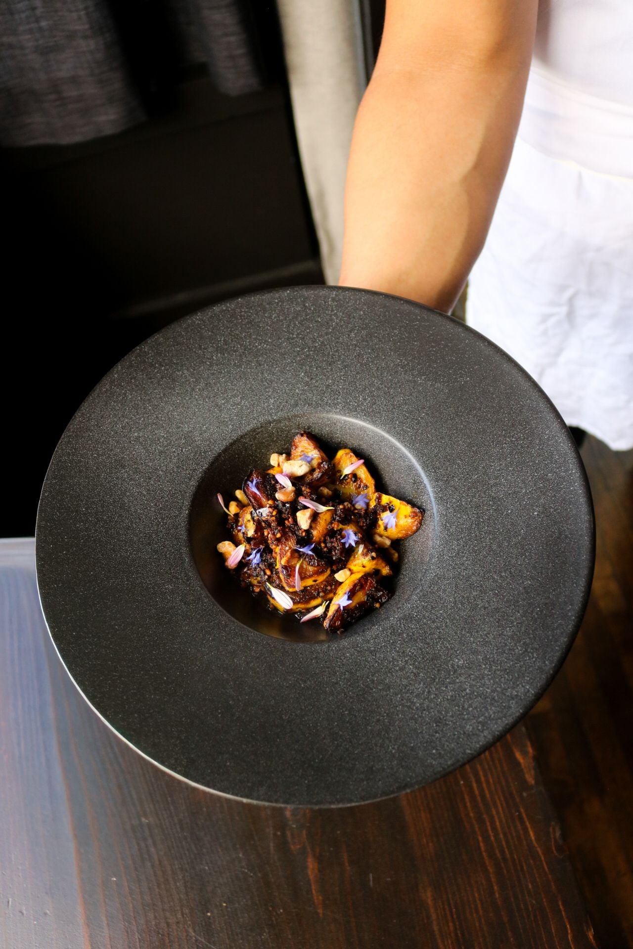 A chef holds an artfully plated dish
