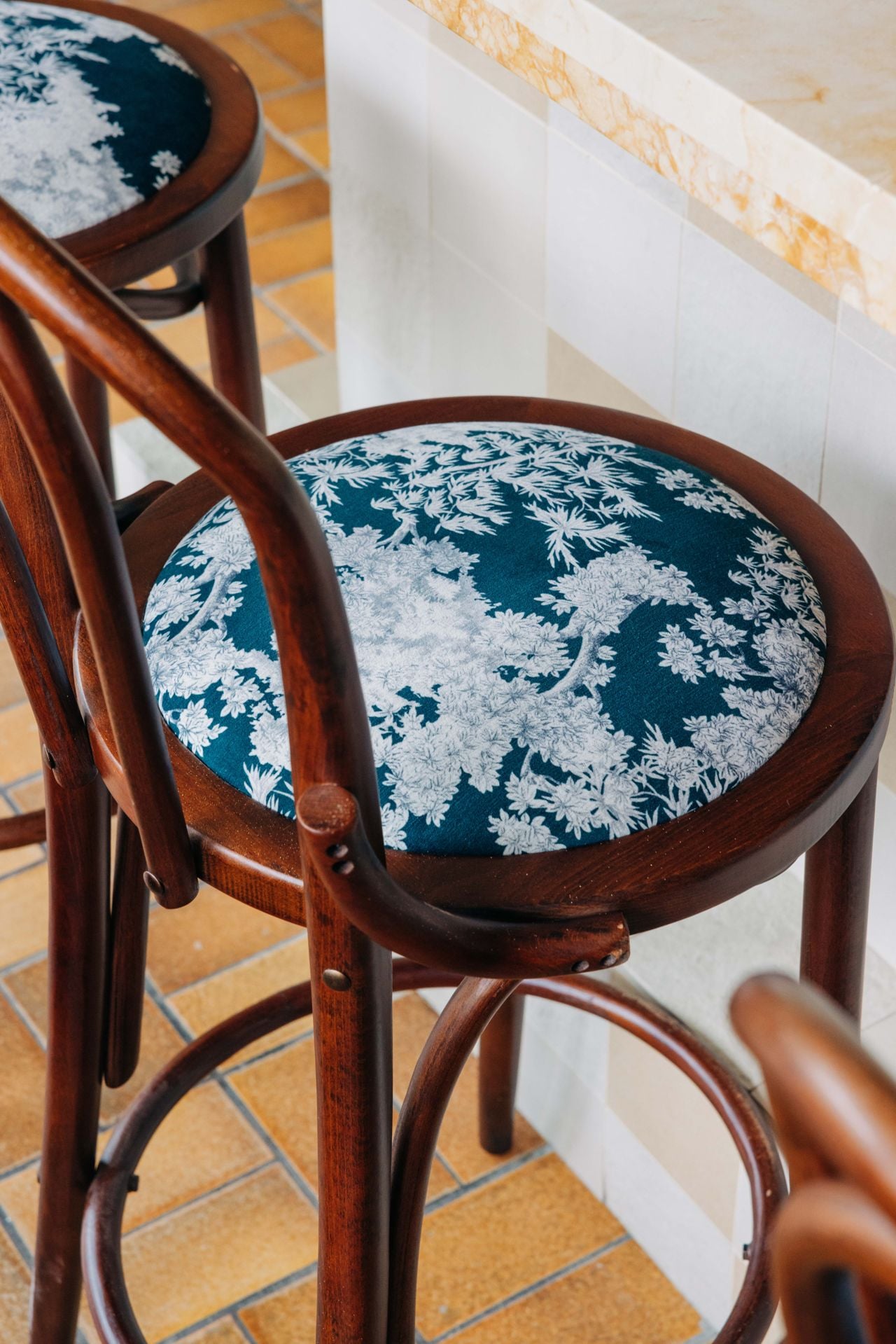 A closeup of a chair upholstered in decorative fabric