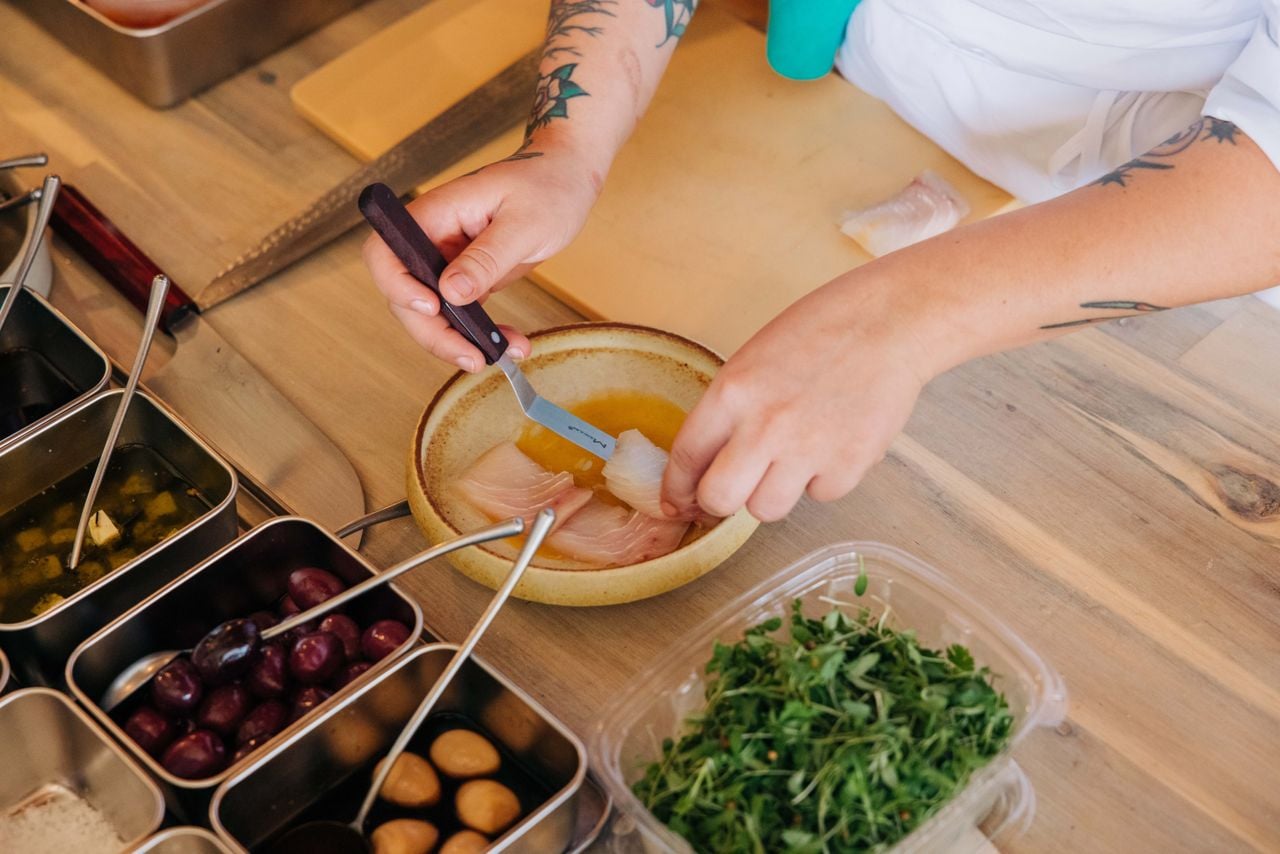 A chef prepares a cured fish dish