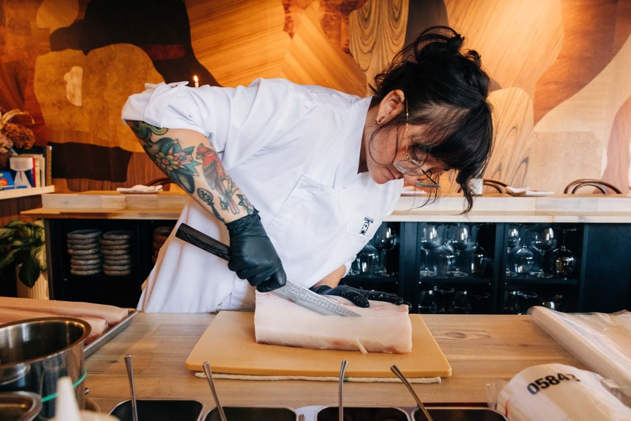 A chef slices into a large piece of fish
