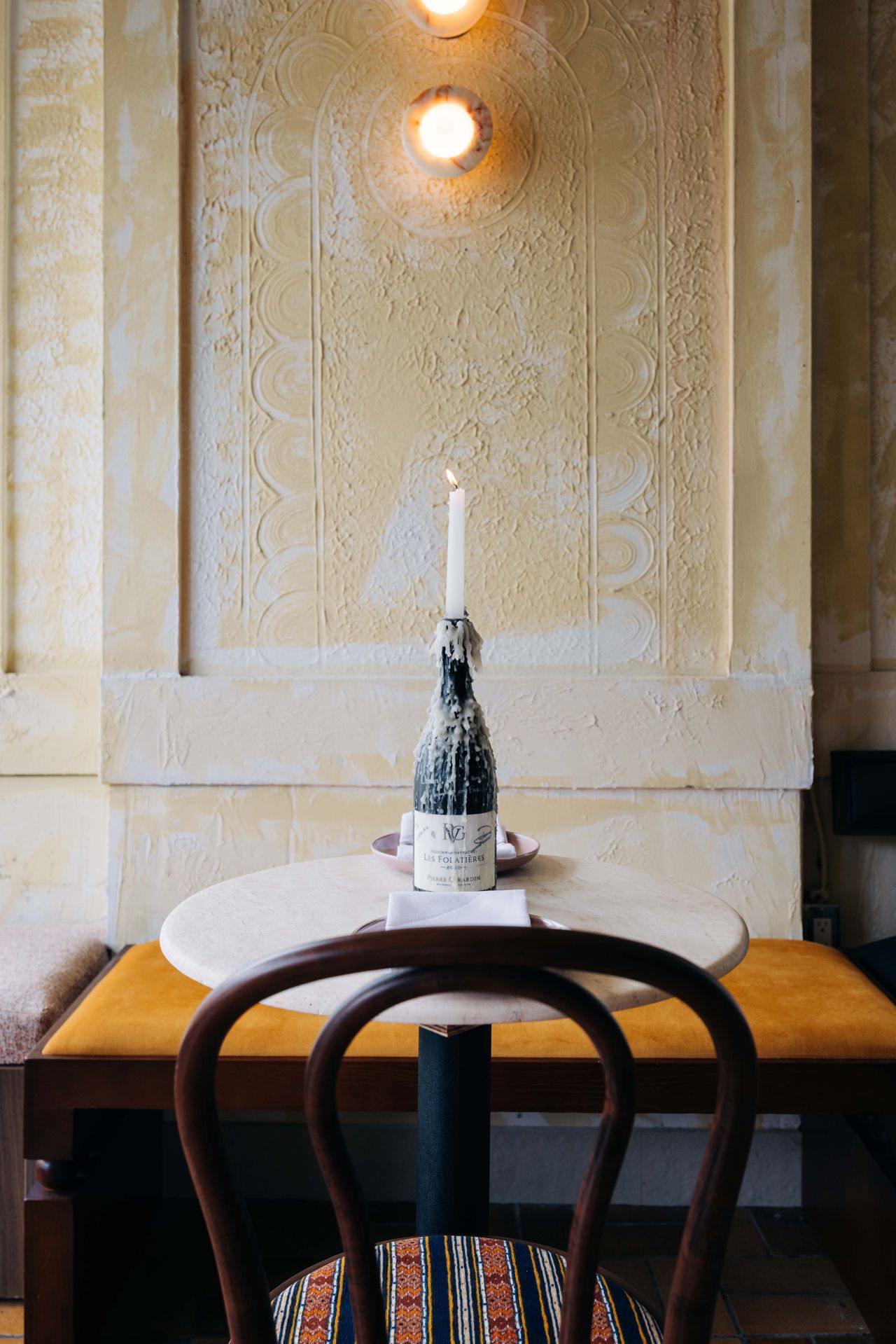 Candles in wine bottles serve as centrepieces at Antylia