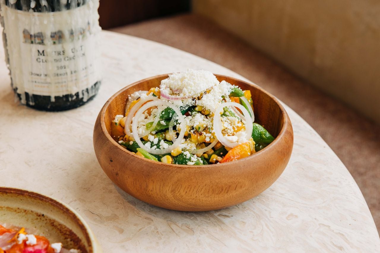 Local heirloom tomatoes, blanched runner beans, charred sweet corn and golden physalis come together in a bright vinaigrette of serrano chilies, stewed tomatillo and poblano