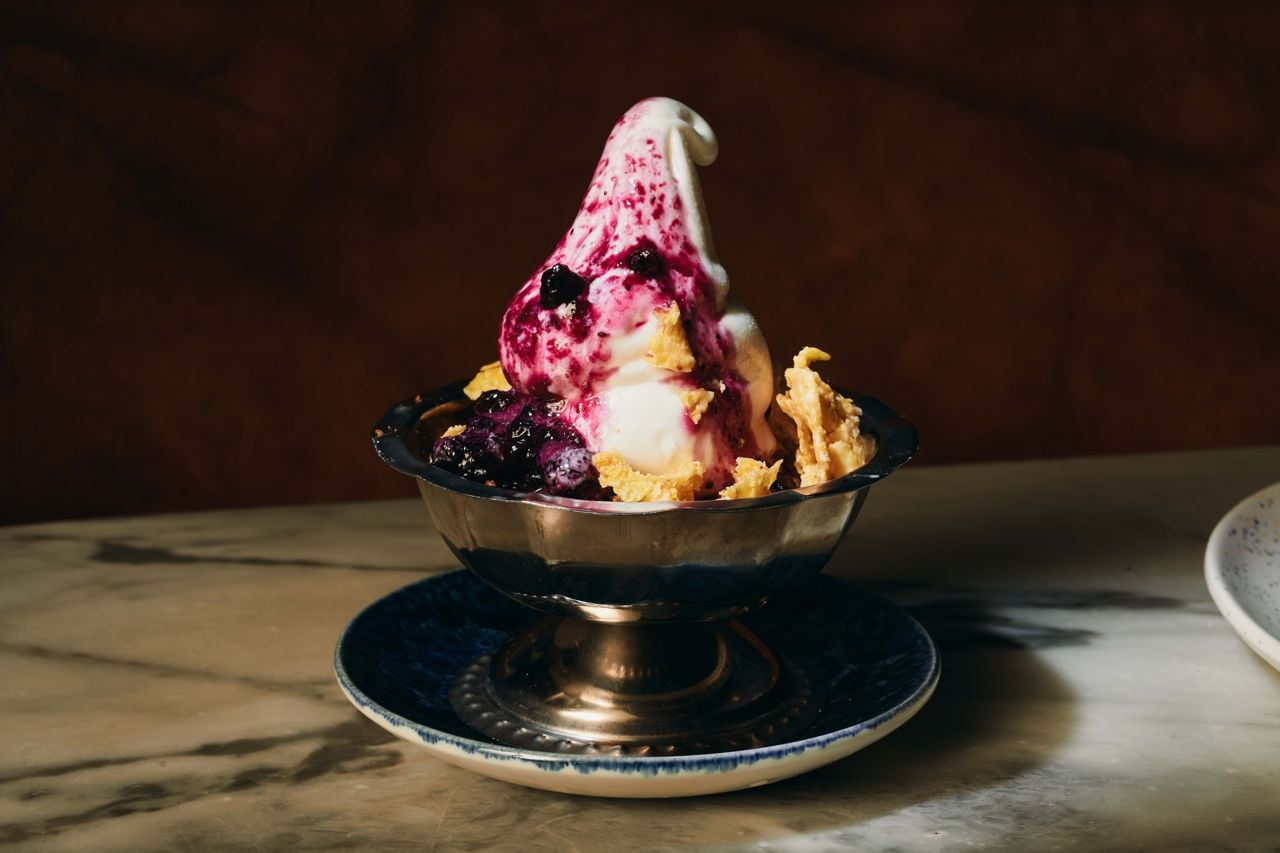A swirl of vanilla-lemon soft serve is topped with a wild Ontario blueberry compote lightly seasoned with French sweet wine vinegar