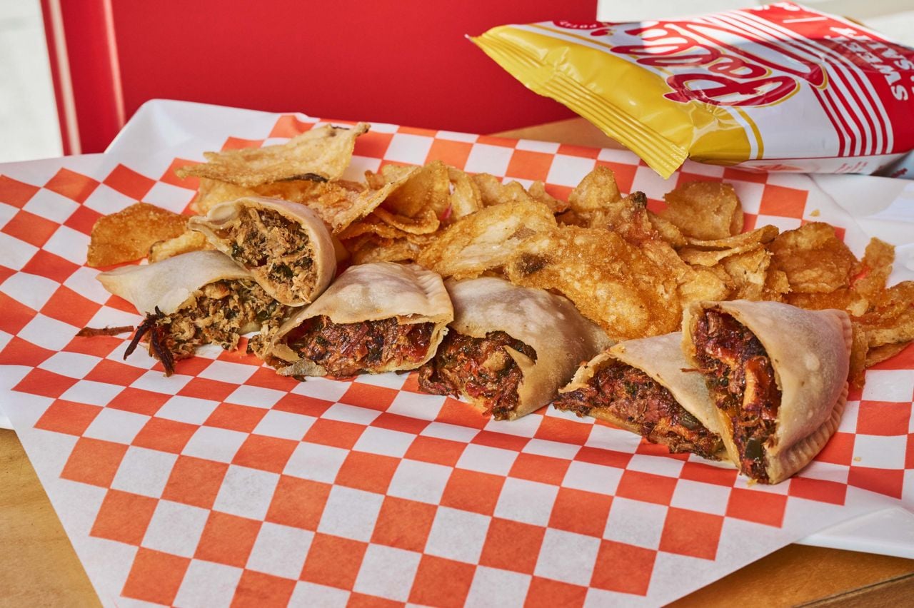 A selection of empanadas with potato chips
