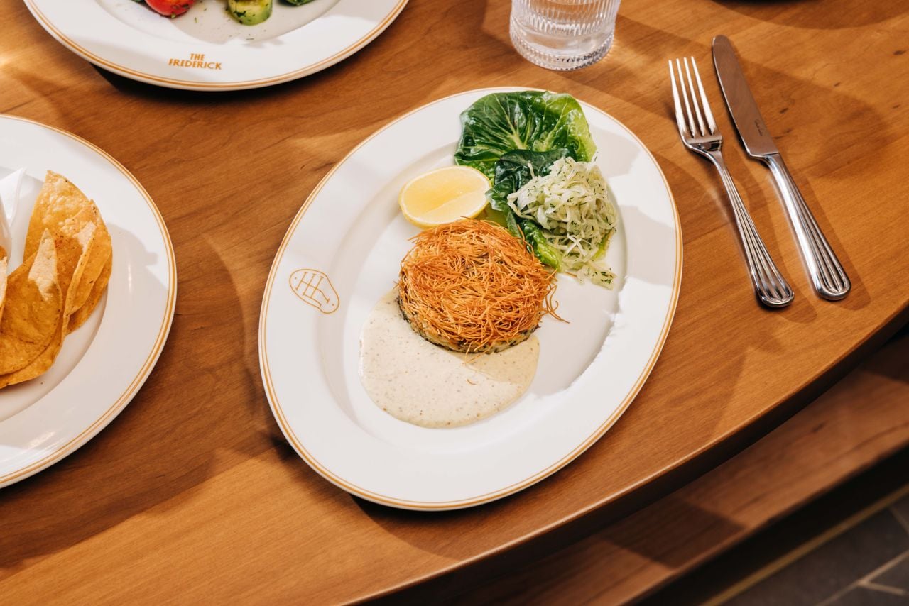 A crab cake topped with crunchy kataifi strands and served with endive slaw