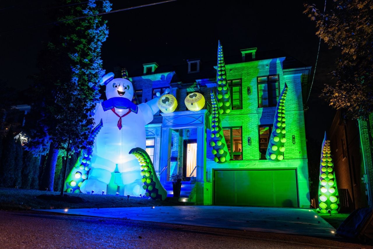 A suburban house decorated for Halloween, with giant tentacles, eye balls and a huge Stay Puft marshmallow man.