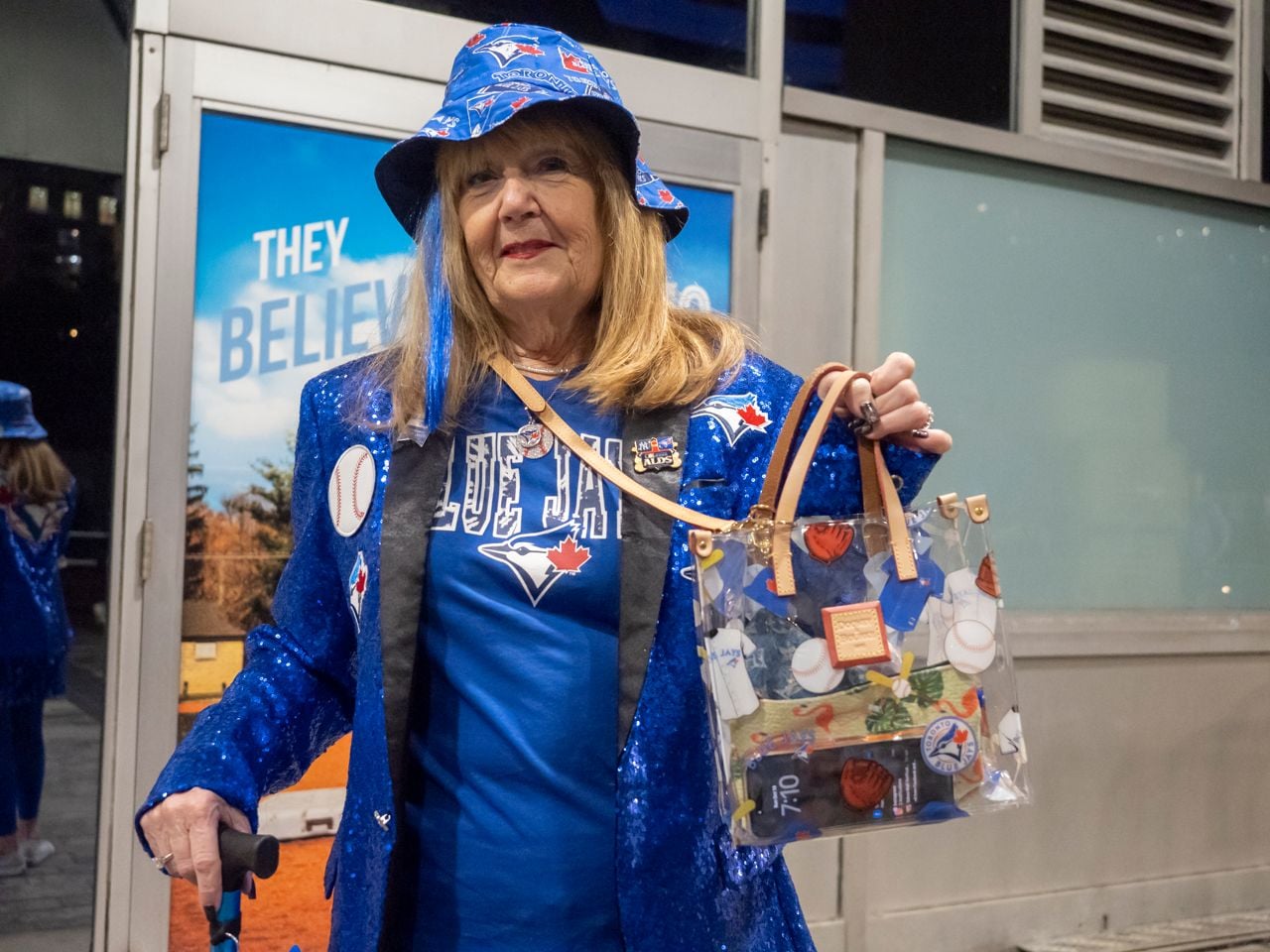Older woman wearing blue sparkly jacket.
