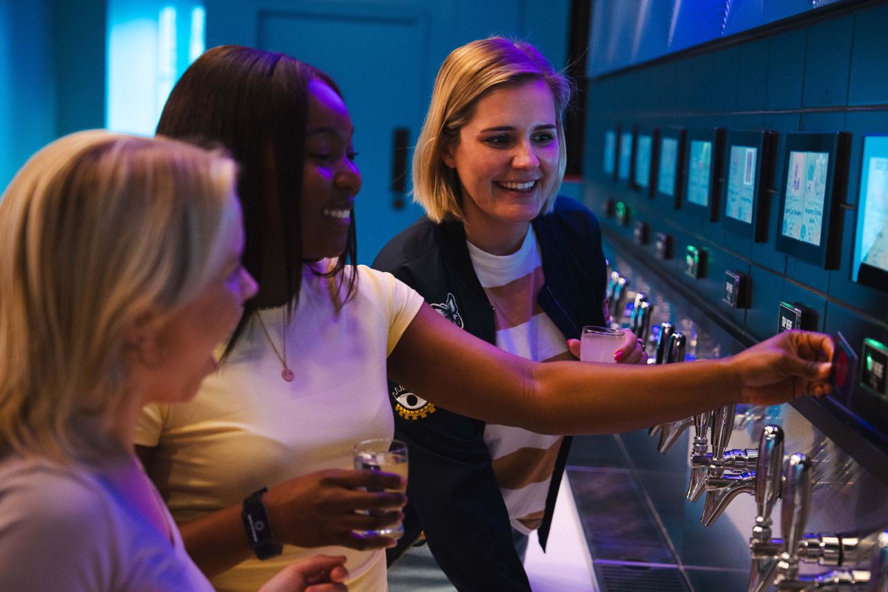 People pour beer from self-serve draught taps at Brkfree in Toronto