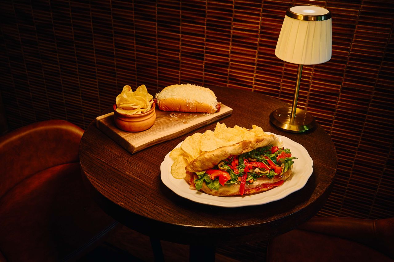 A hot dog with chips and an Italian sandwich