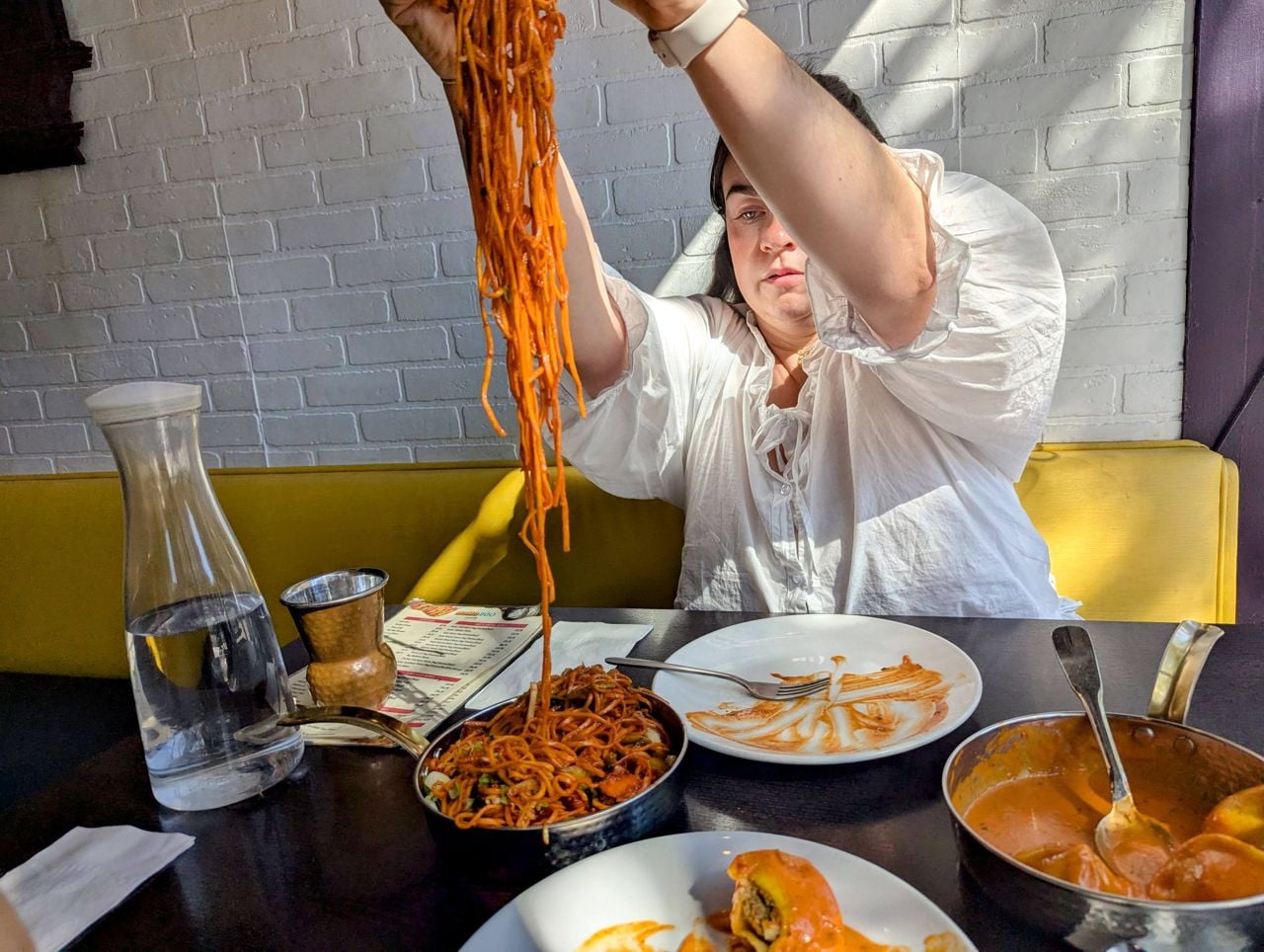 Chef Victoria Rinsma picks up noodles from a dish of special chow mein at Himalayan Kitchen in Toronto