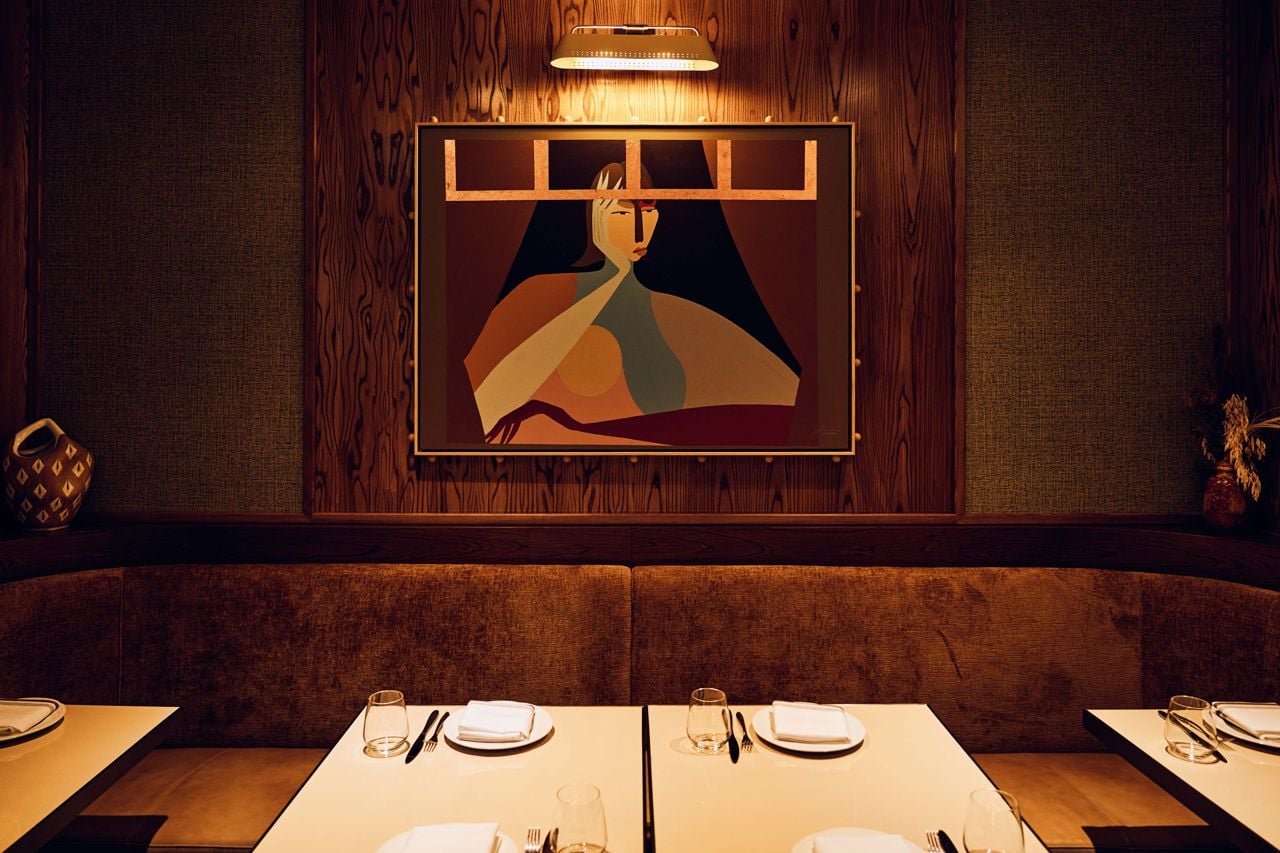 An abstract painting hangs on the wall above tables in the dining room at Eloise