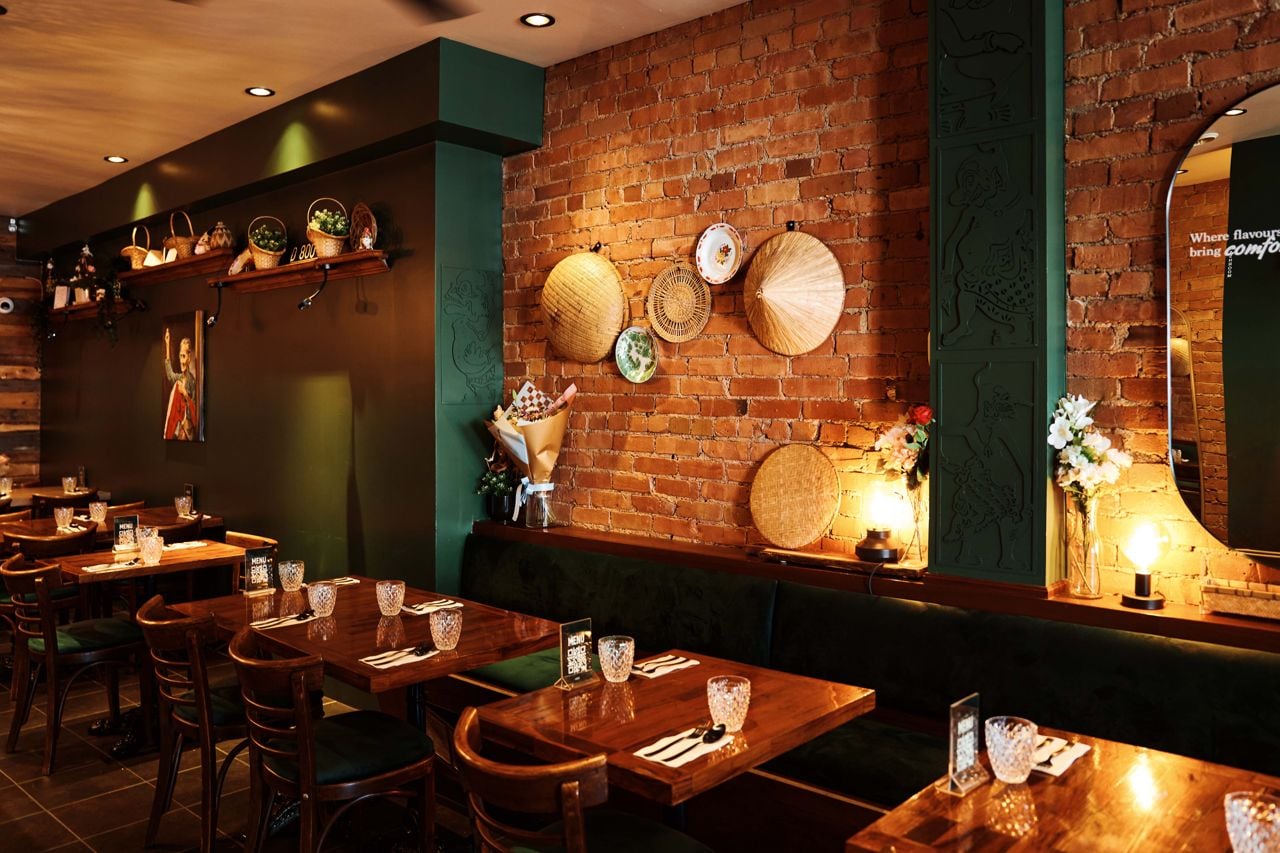 Exposed brick walls are decorated with vintage plates and woven baskets in the dining room of Sambal