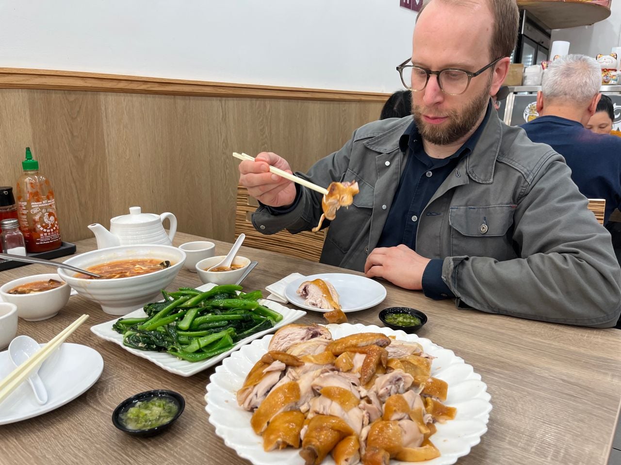 Chef Daniel Hyam uses chopsticks to pick up a piece of soy chicken