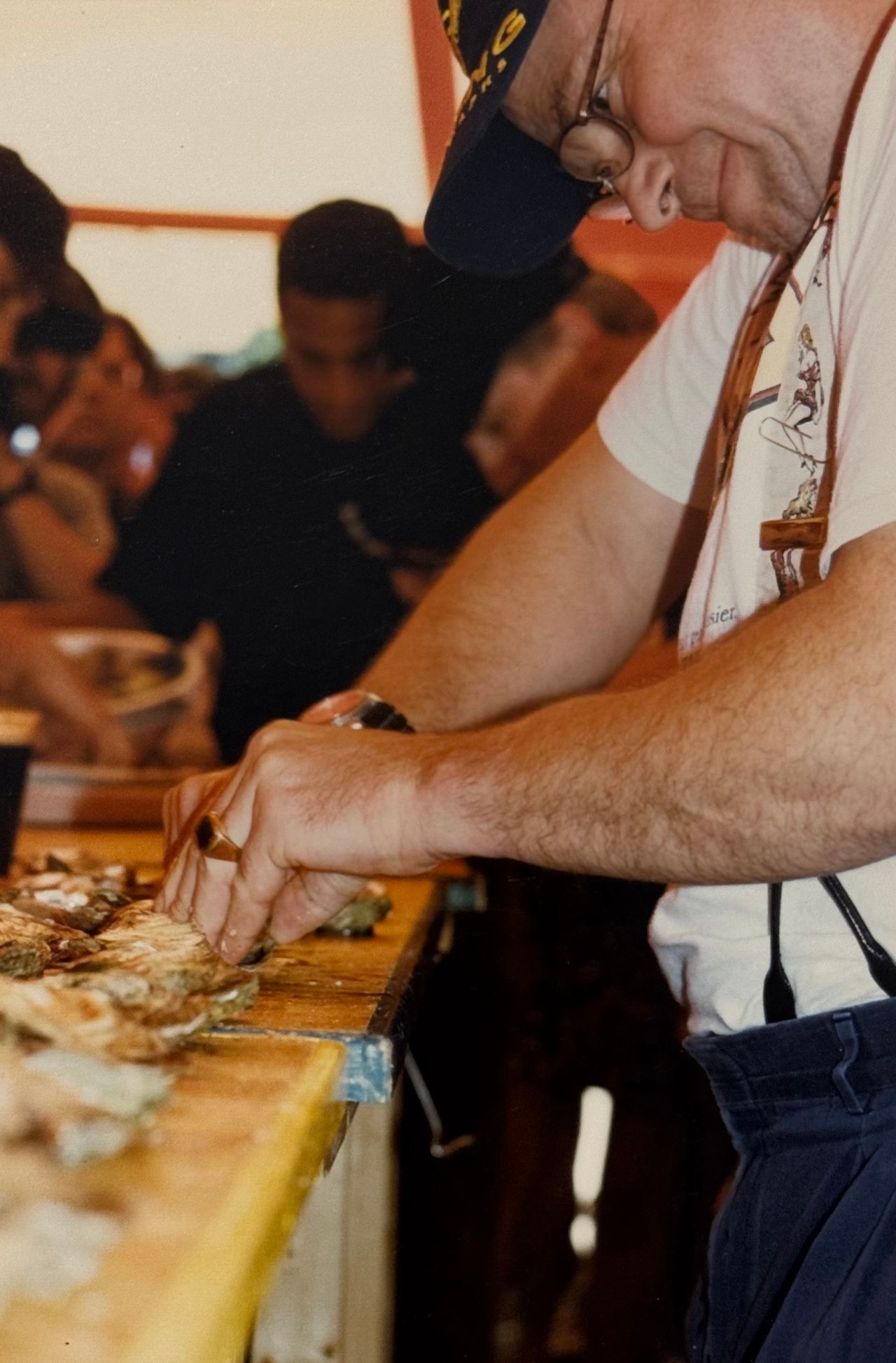 A closeup of Rodney Clark shucking oysters