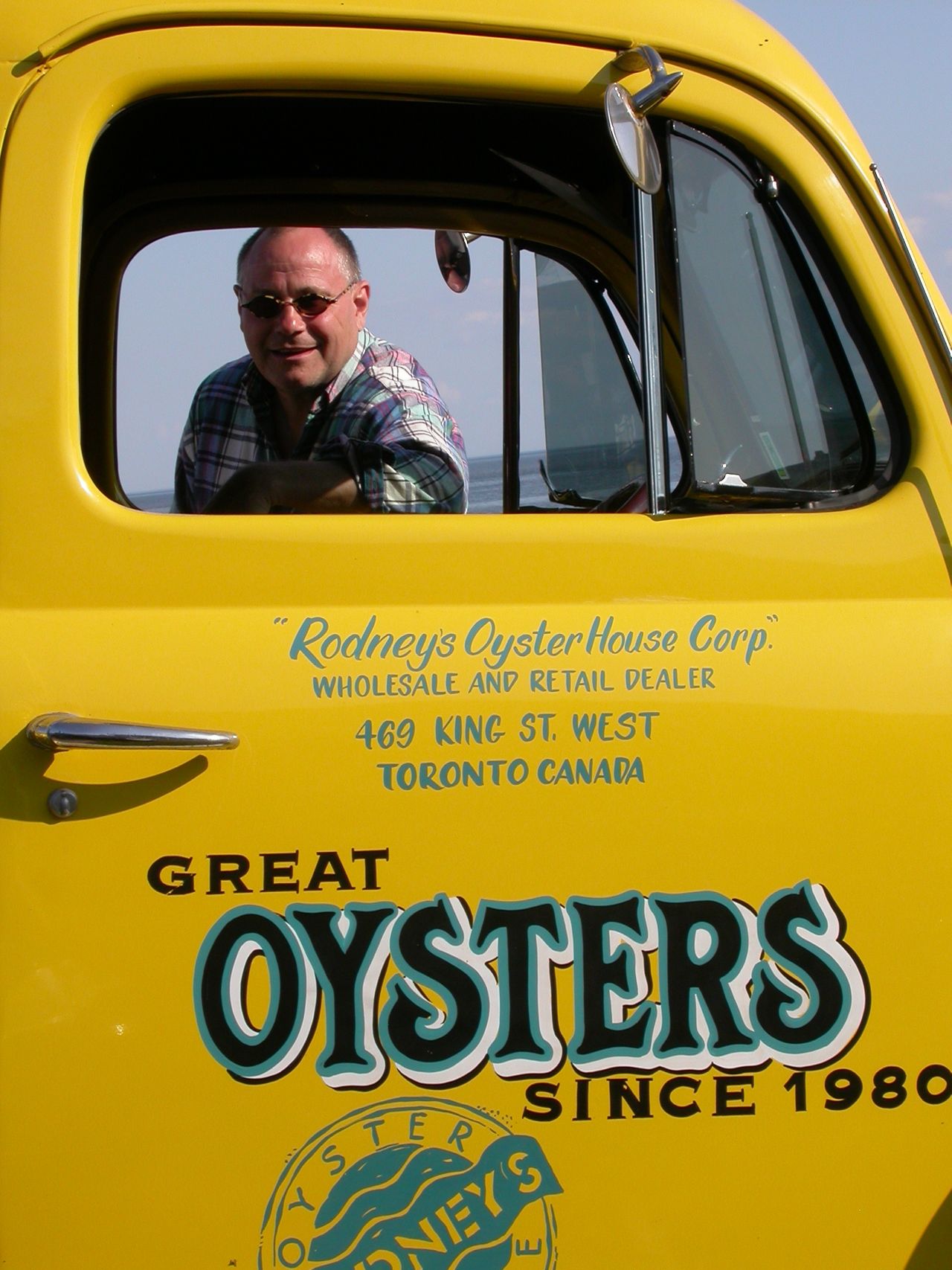 Rodney Clark looks through the window of his yellow pickup truck