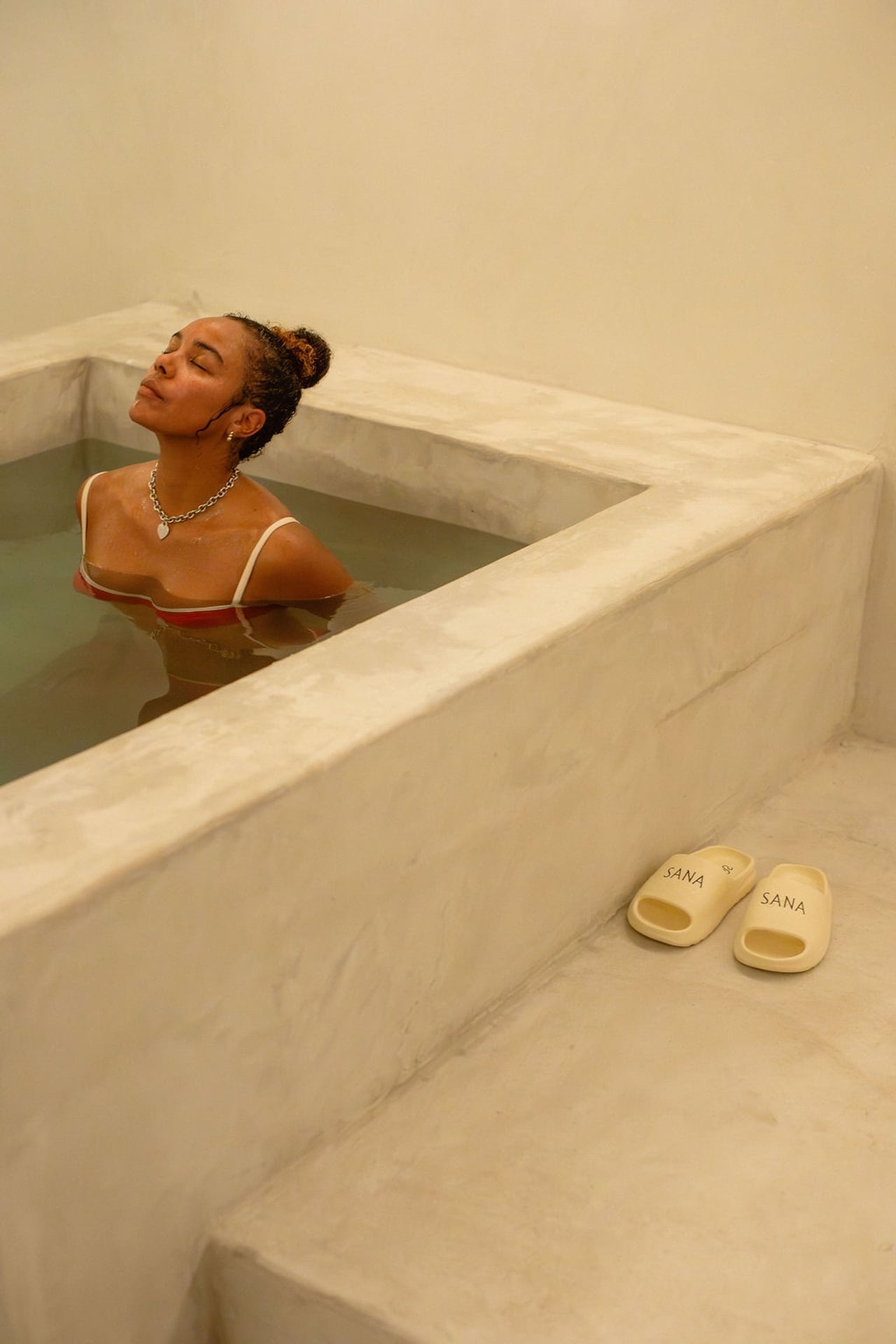 A woman in a cold plunge bath at Sana