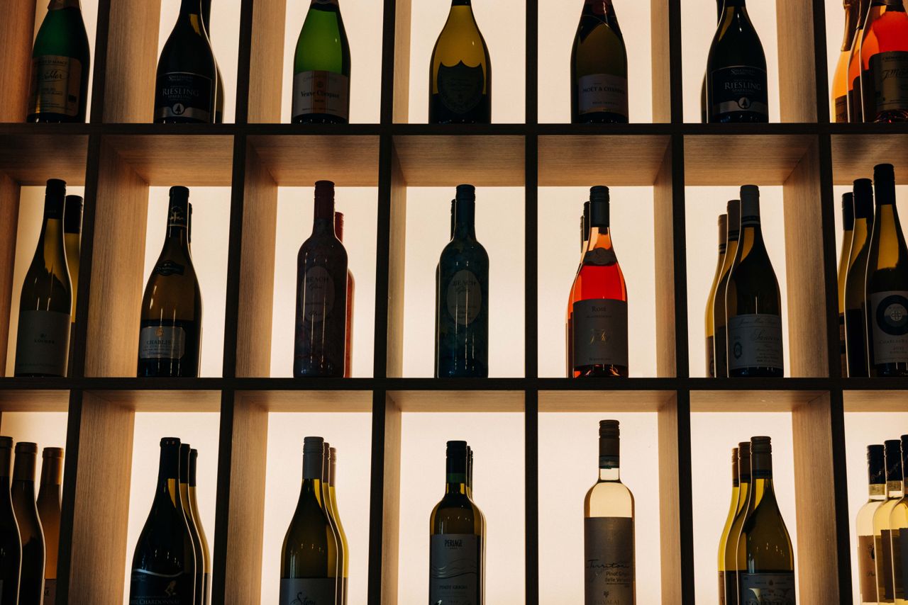 Shelves of backlit wine bottles