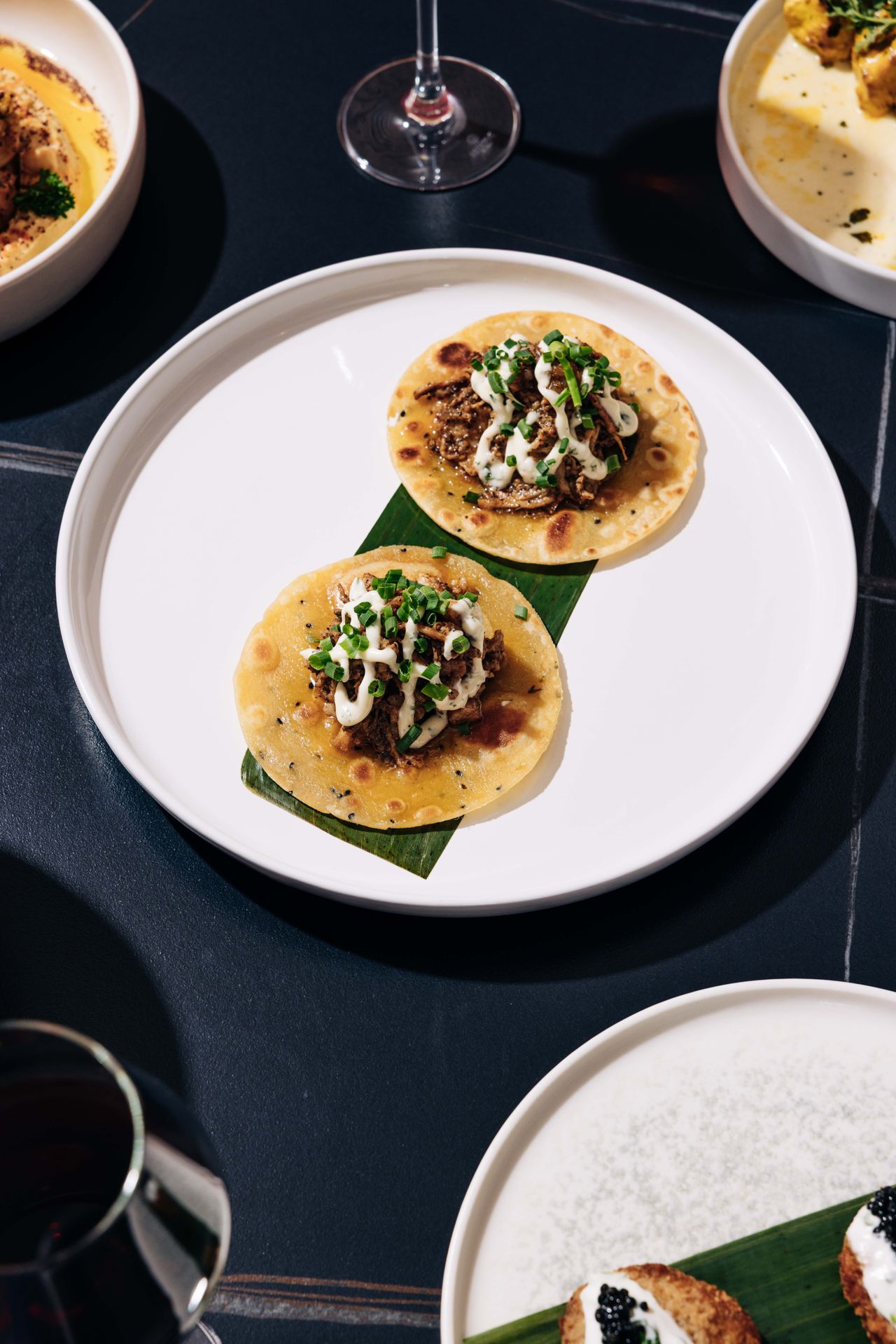 Two slow-cooked pork tacos on paratha