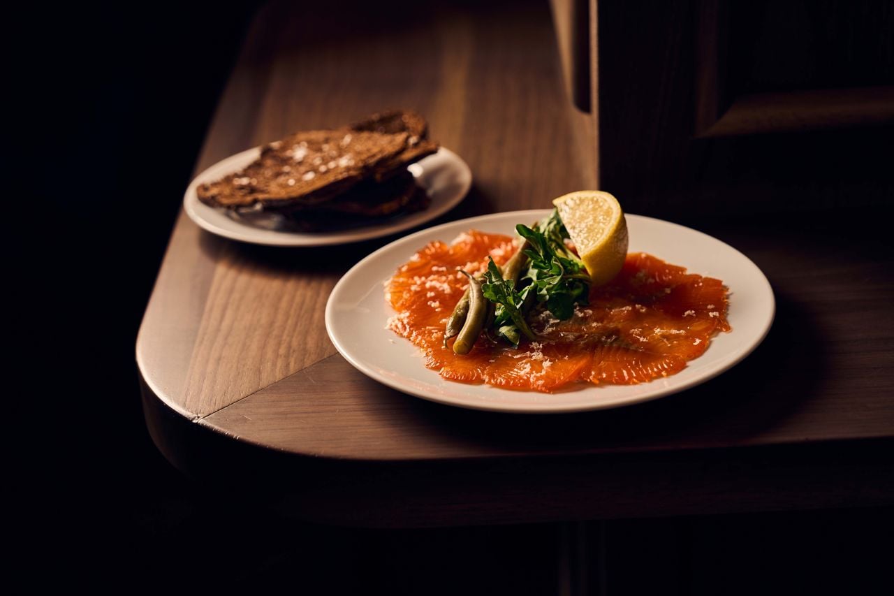The crimson trout is cured overnight, then house-smoked and served over a base of horseradish cream, and finished with watercress and lemon