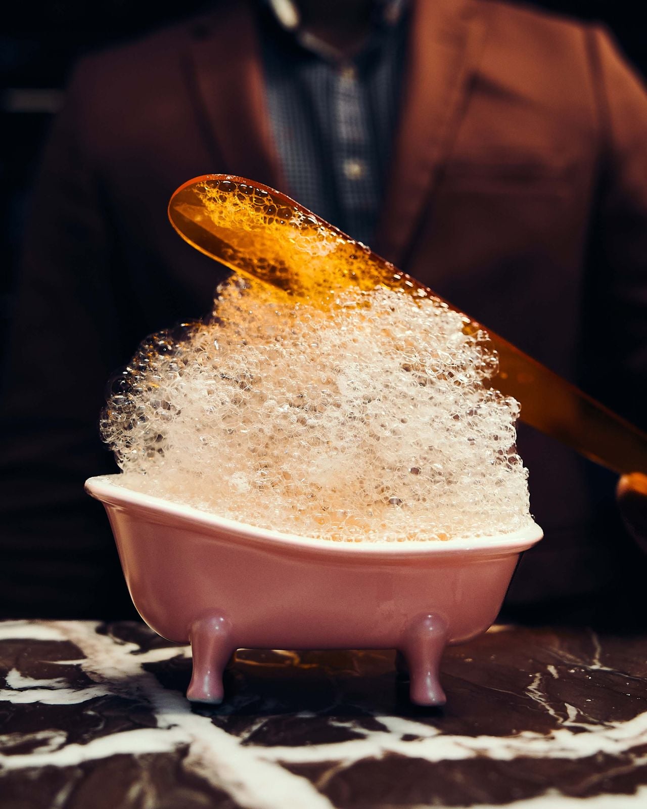A mini bathtub filled with a bubbly cocktail