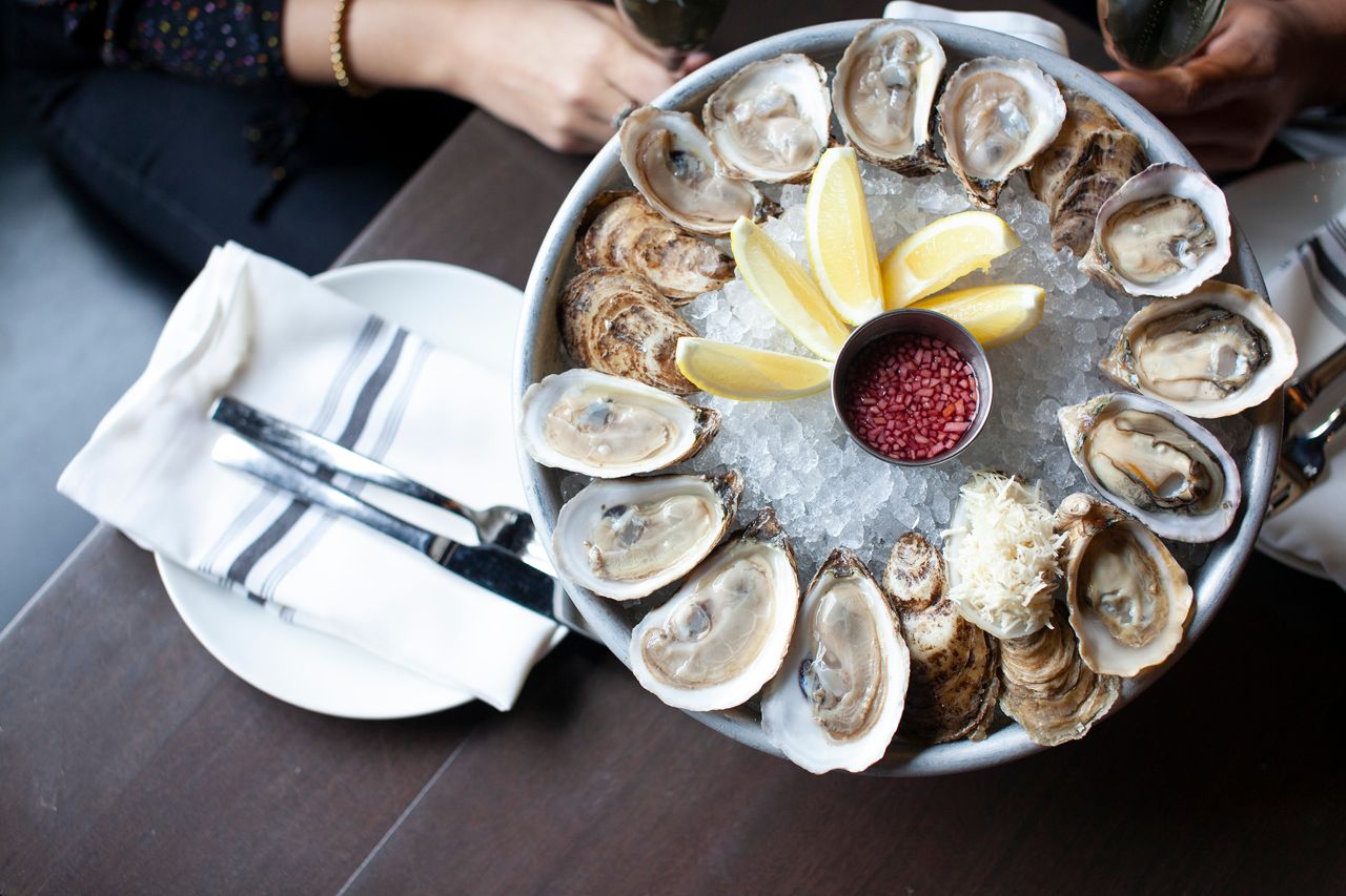 A tray of a dozen shucked oysters on ice