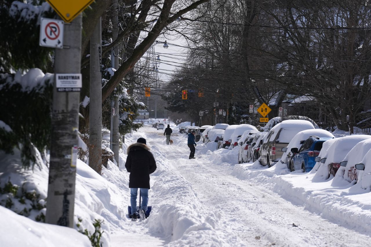 People shovelling on a snowy street