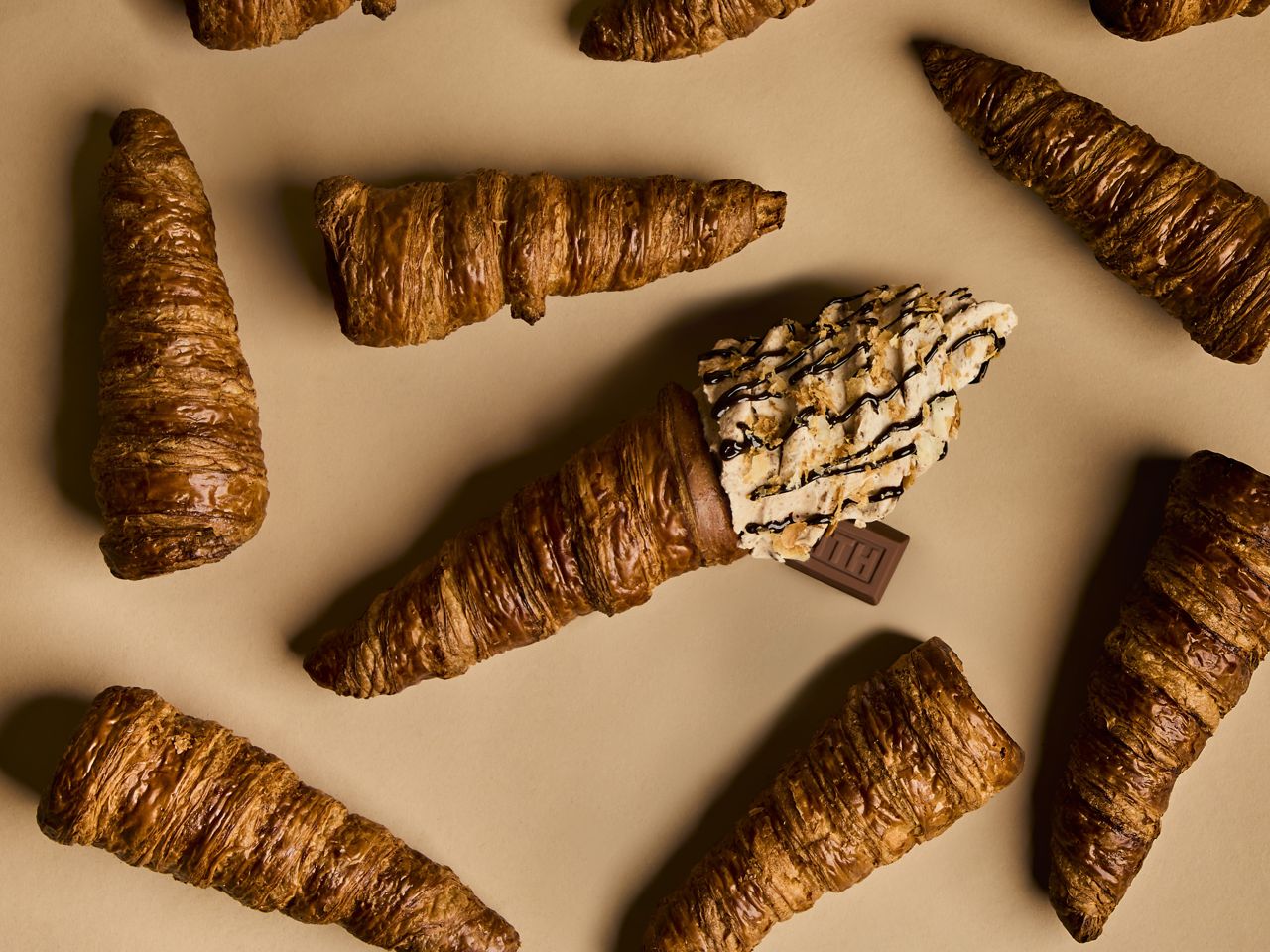 Ice cream in a croissant cone is surrounded by croissants