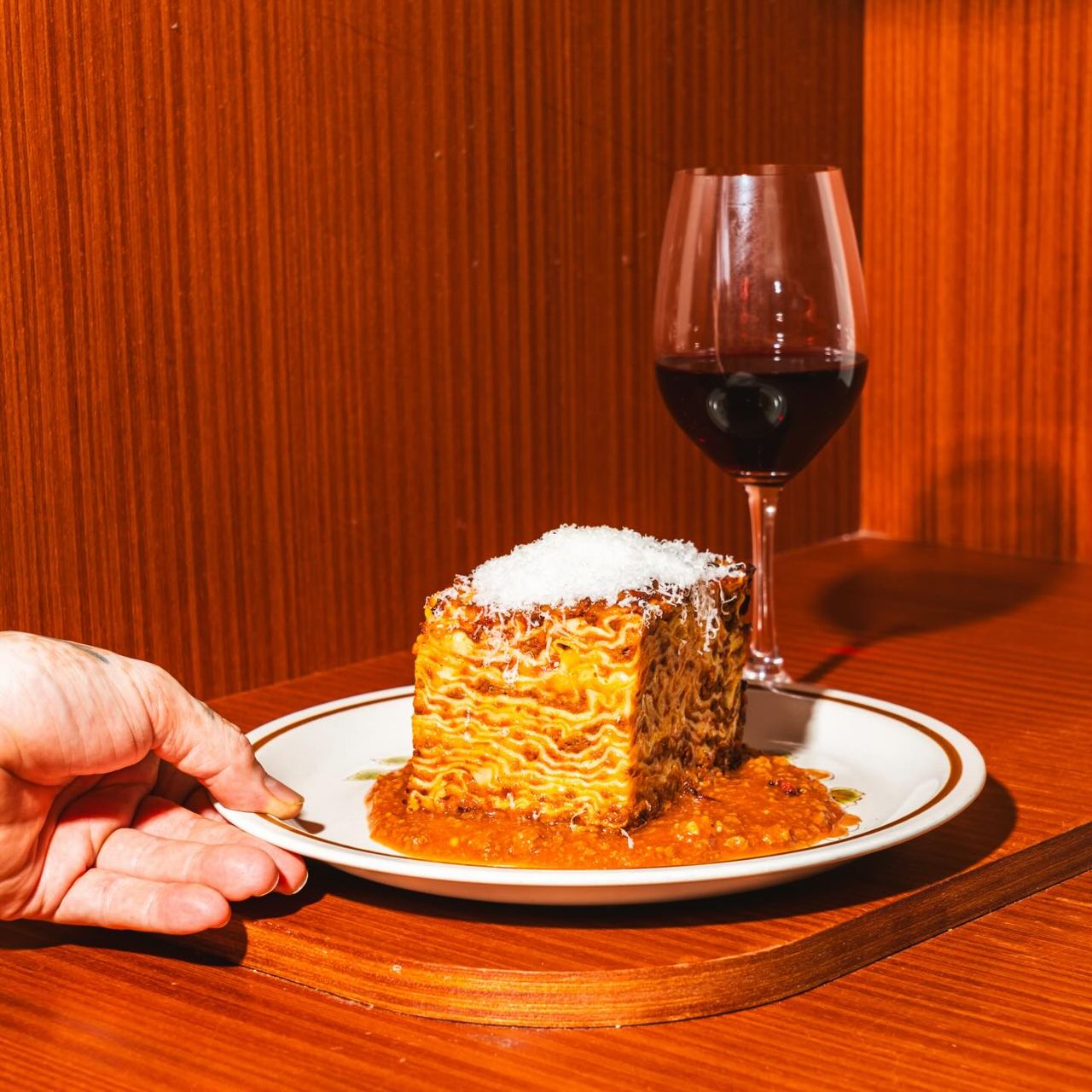 A helping of lasagna and a glass of red wine