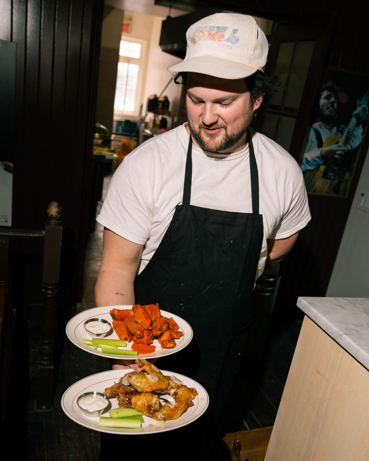 Allen Meredith holds two plates of chicken wings