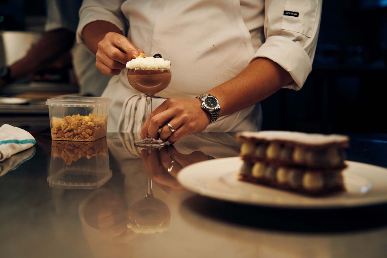 A chef puts the finishing touches on a dessert