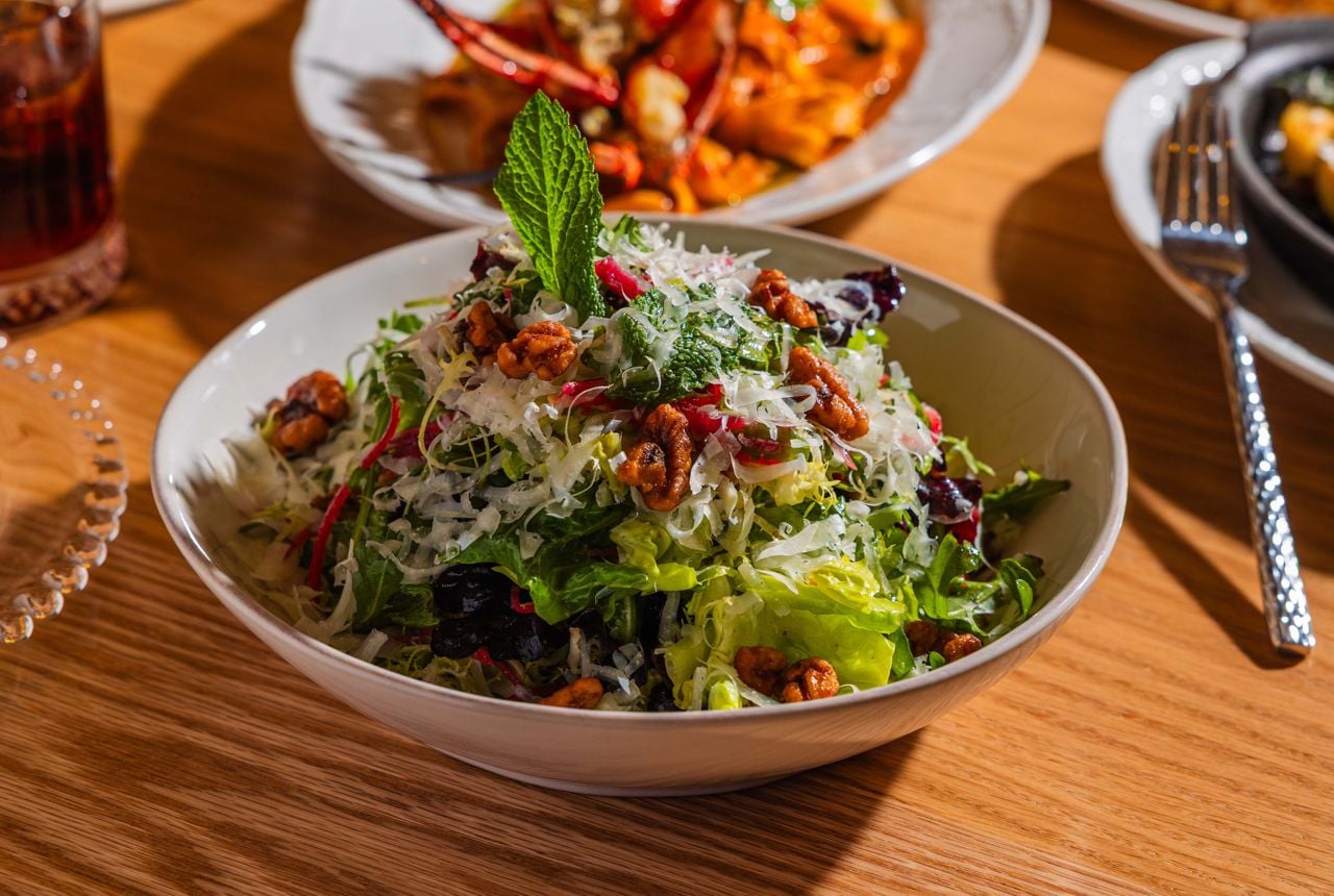 For the Insalata Alba, a base of gem lettuce, arugula and frisée is finished with a white balsamic and organic honey dressing, shaved parmesan and an amalgam of summery toppings, including candied walnuts, fresh mint, pickled red onion and red radish