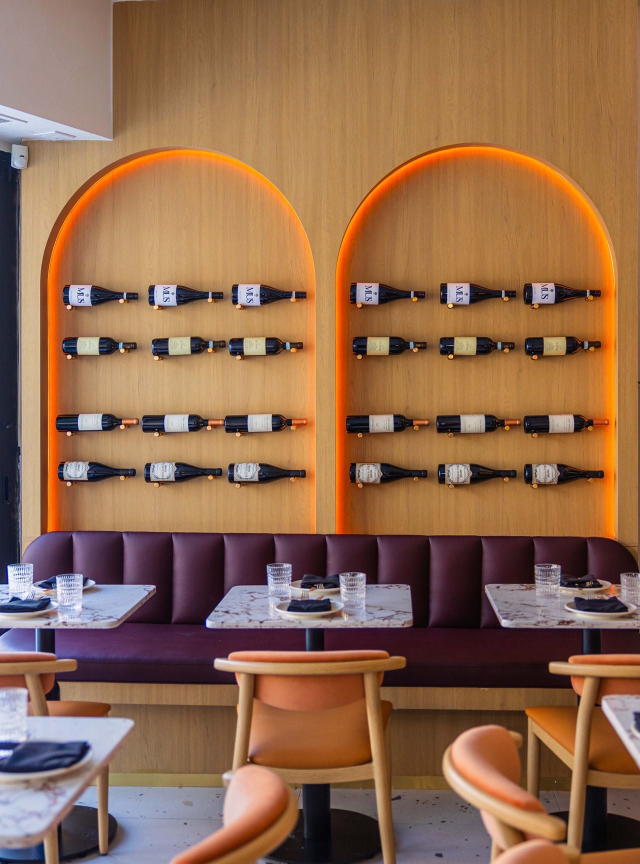 Wine bottles line one wall of Osteria Alba's dining room