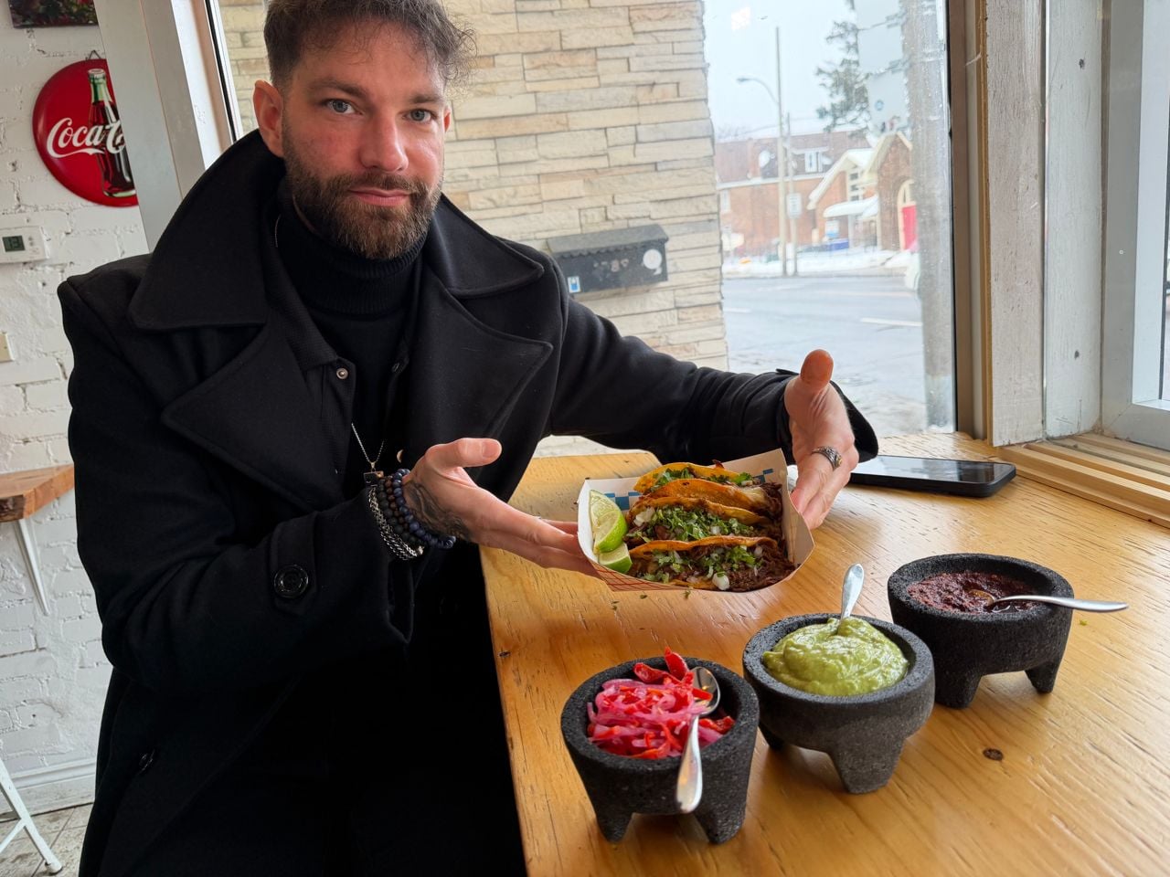 Chef Romain Avril holds up an order of tacos at Tacos Casa Sonora