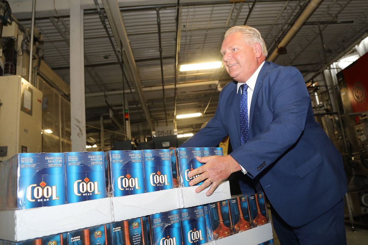 Ontario Premier Doug Ford pushes a pallet of beer cases.