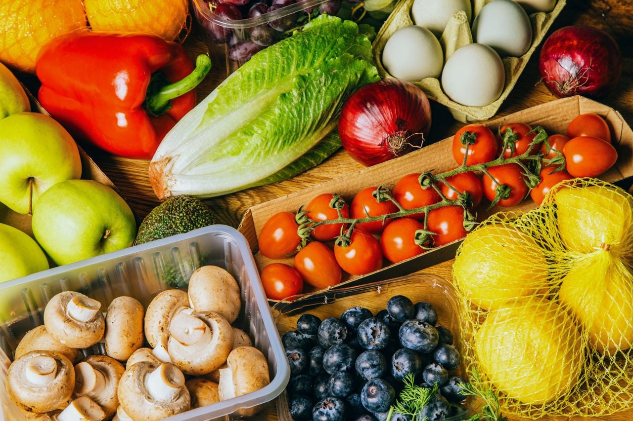 A vibrant selection of fresh fruits and vegetables displayed on a wooden table.