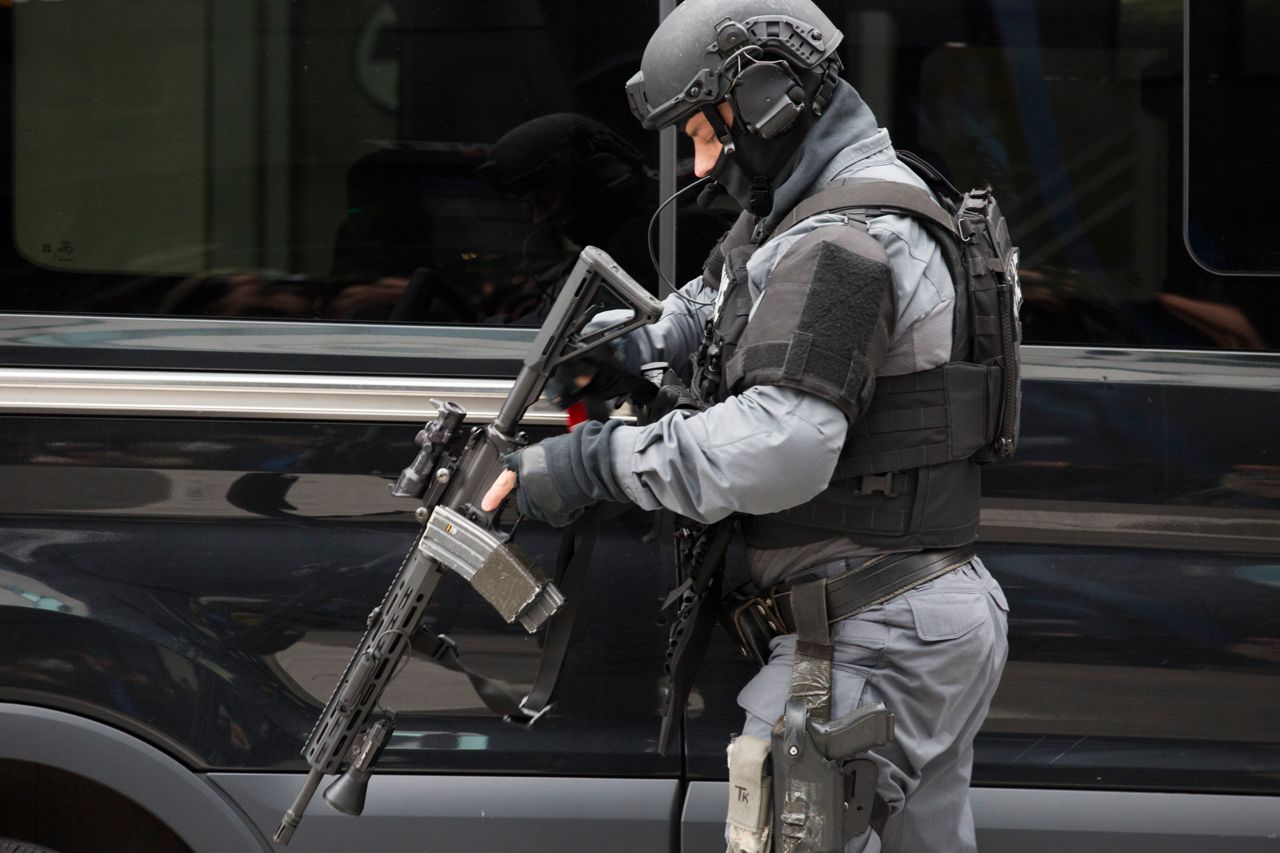 A Toronto police officer carries a large patrol rifle.