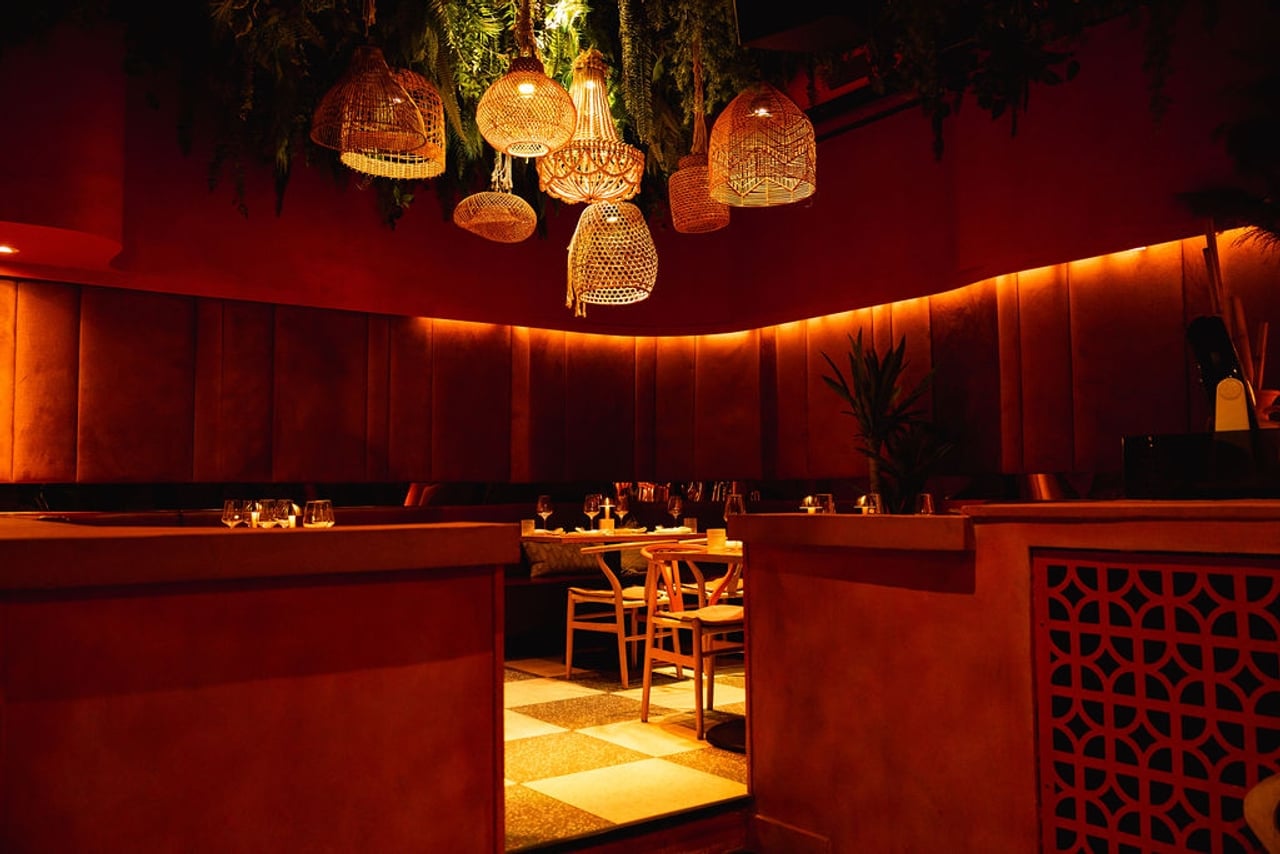 Rich, red restaurant with a cluster of hanging rattan lights