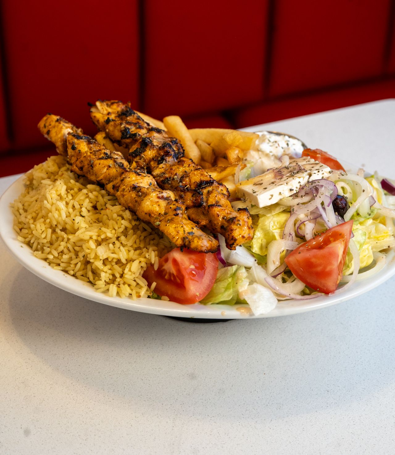 Chicken souvlaki with rice, salad and fries