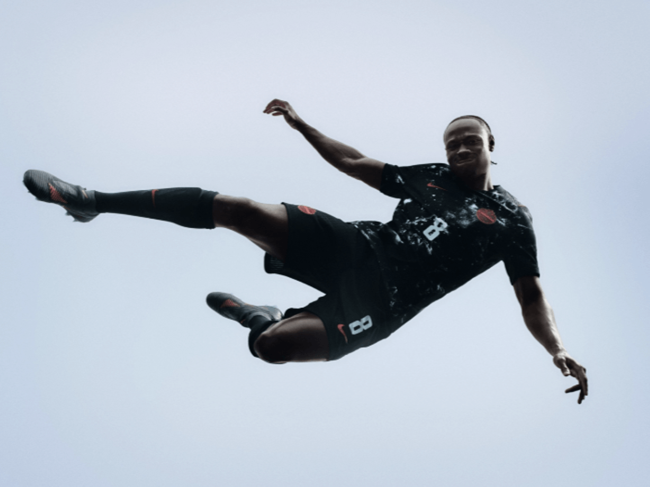 An athlete jumps while modelling the Team Canada soccer jersey for 2026 FIFA World Cup away games.