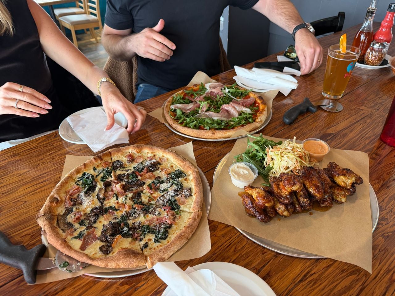 A spread of pizza, chicken wings and beer at Pie, a pizza restaurant in Barrie